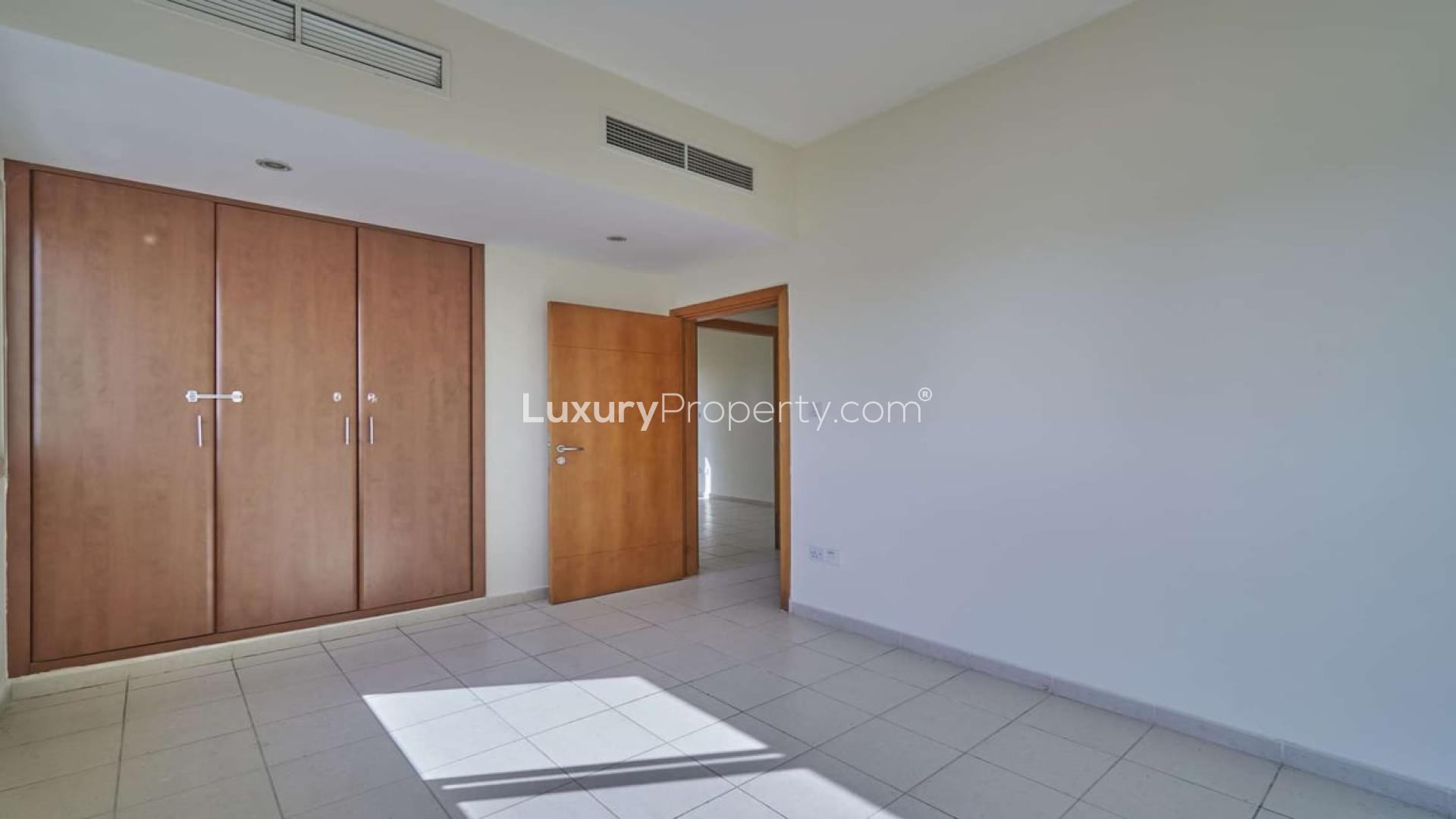 Bright bedroom with built-in wardrobes and balcony in The Views 3-bedroom apartment for rent