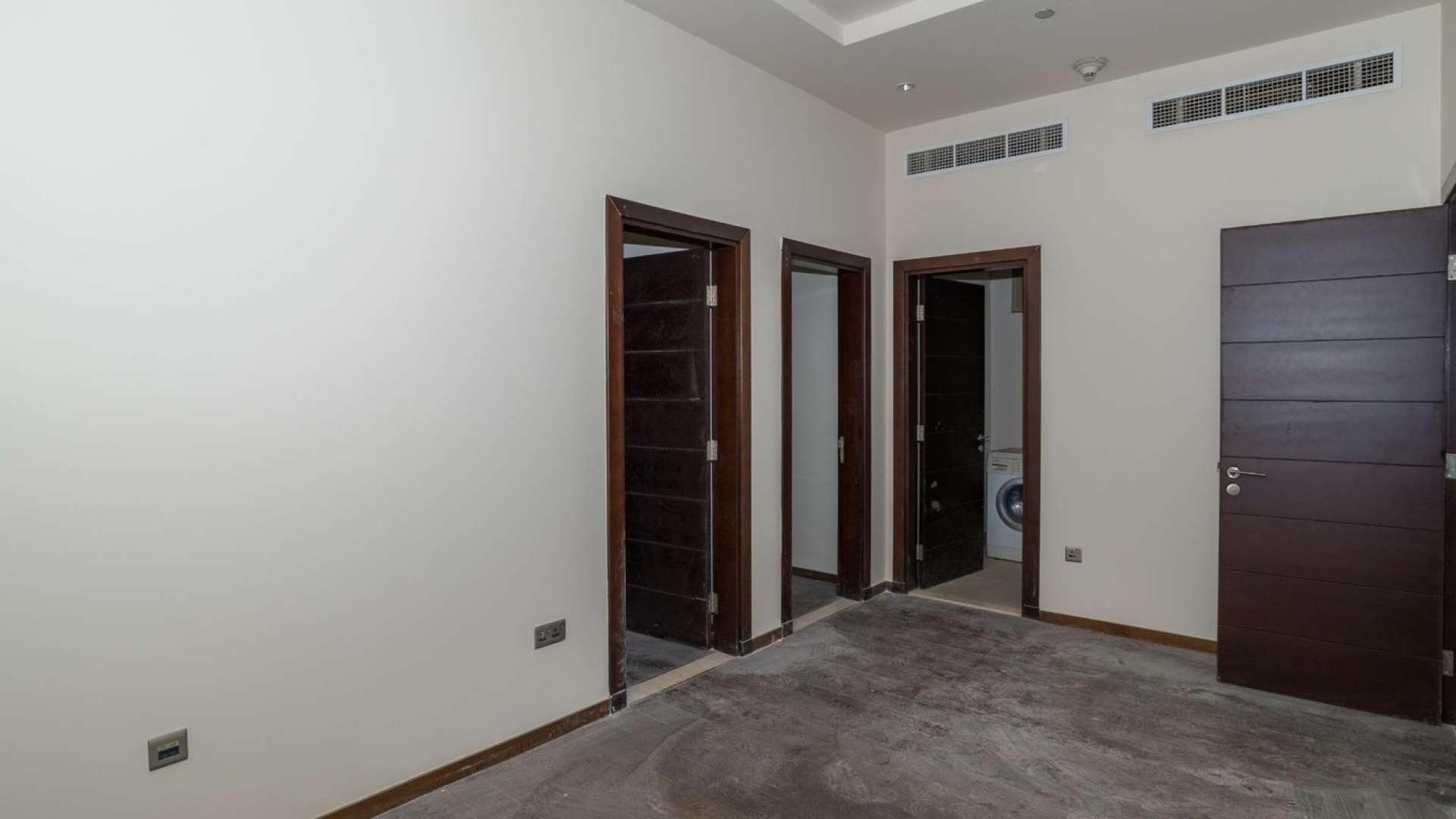 Empty room with dark wood doors in Tiara Residences apartment, Palm Jumeirah