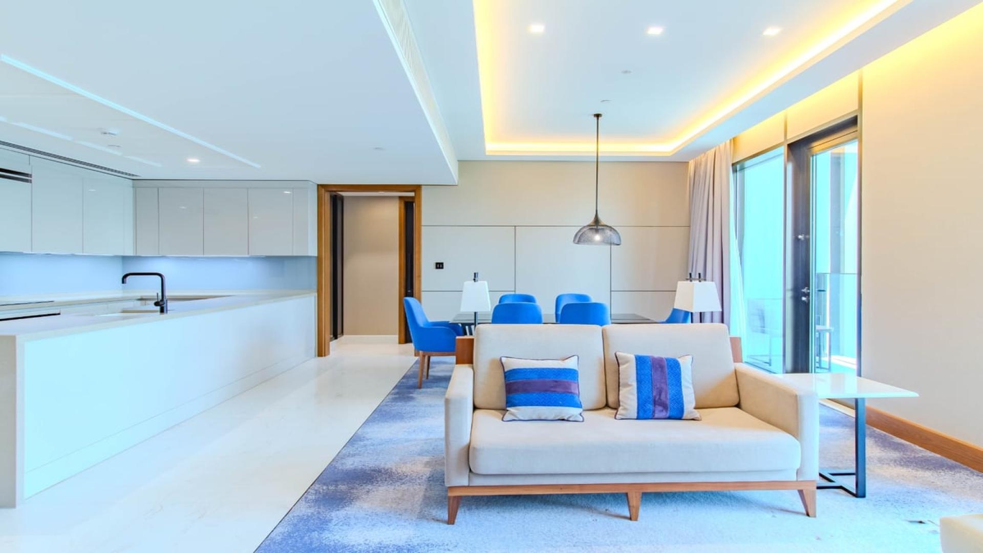 Modern living room in Bluewaters apartment, open kitchen design, bright decor, Ain Dubai view