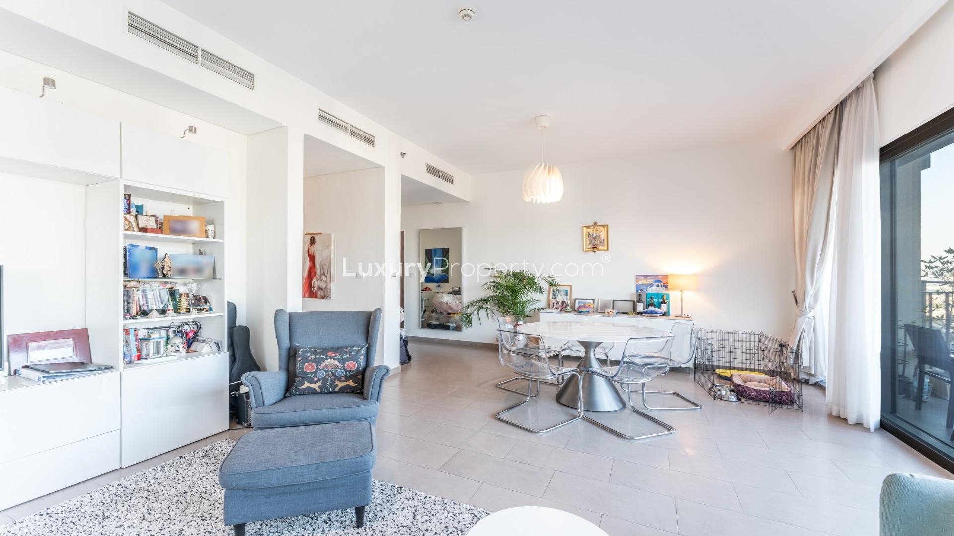 "Balcony view from Dubai Hills Estate apartment overlooking modern buildings and boulevard at Park Heights.",Modern living room in Dubai Hills Estate apartment with elegant decor and natural light