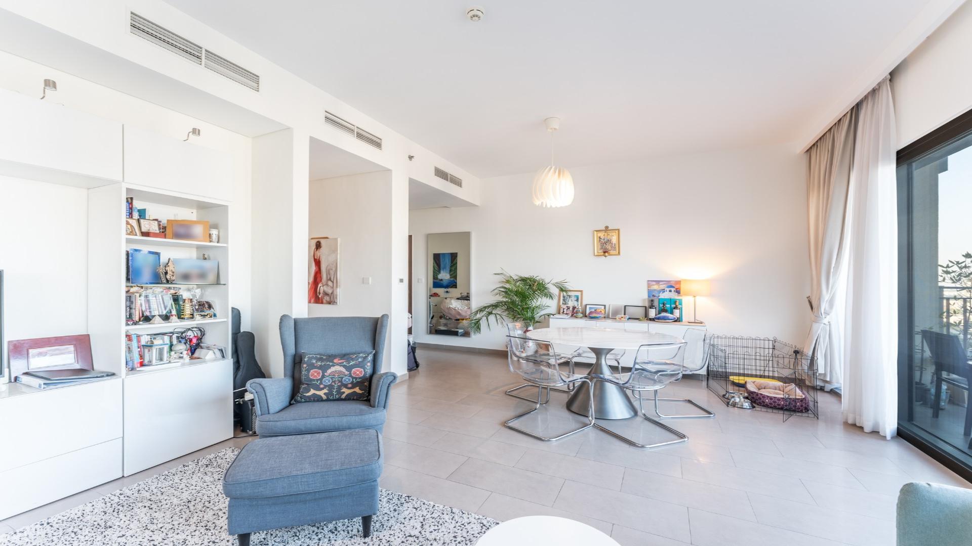 "Balcony view from Dubai Hills Estate apartment overlooking modern buildings and boulevard at Park Heights.",Modern living room in Dubai Hills Estate apartment with elegant decor and natural light