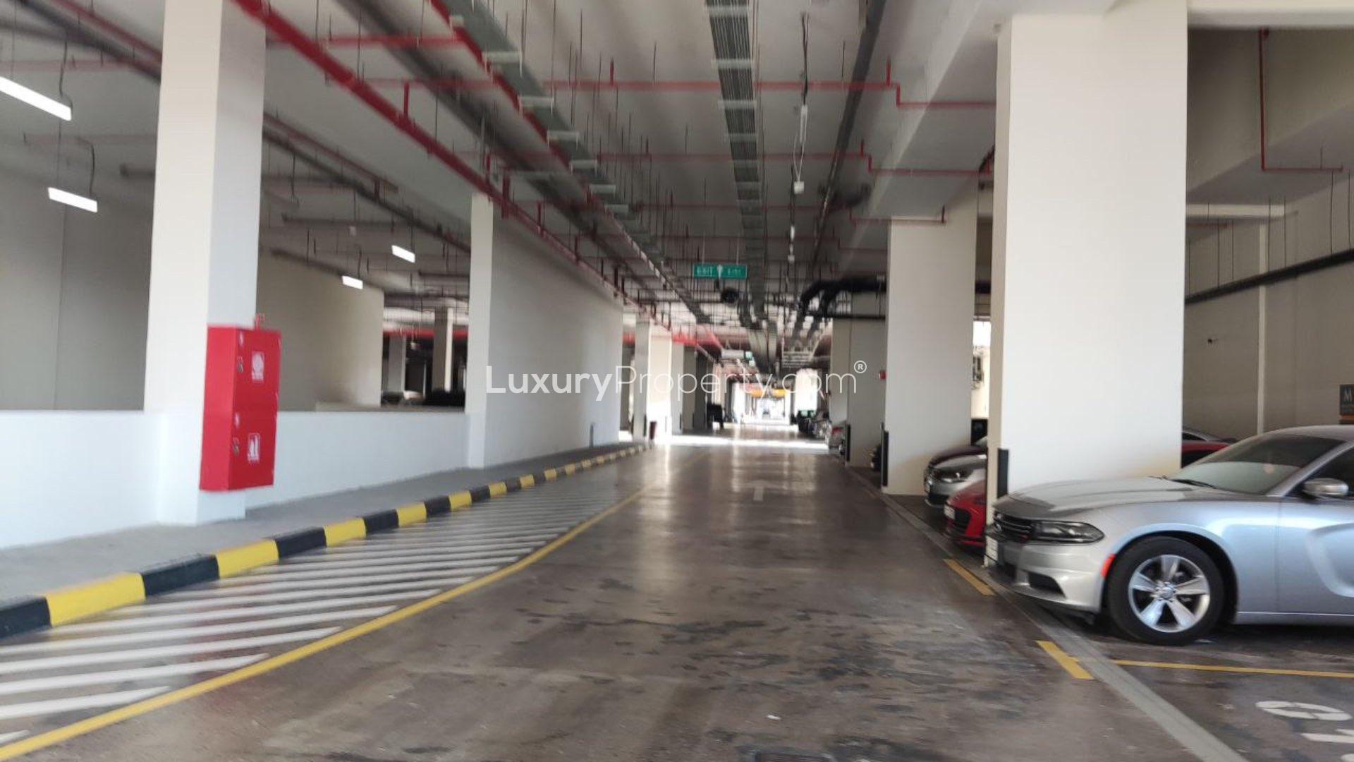 "Exterior view of modern apartment building for sale in Al Jaddaf, featuring spacious balconies.",Underground parking area of spacious 3-bedroom apartment for sale in Al Jaddaf