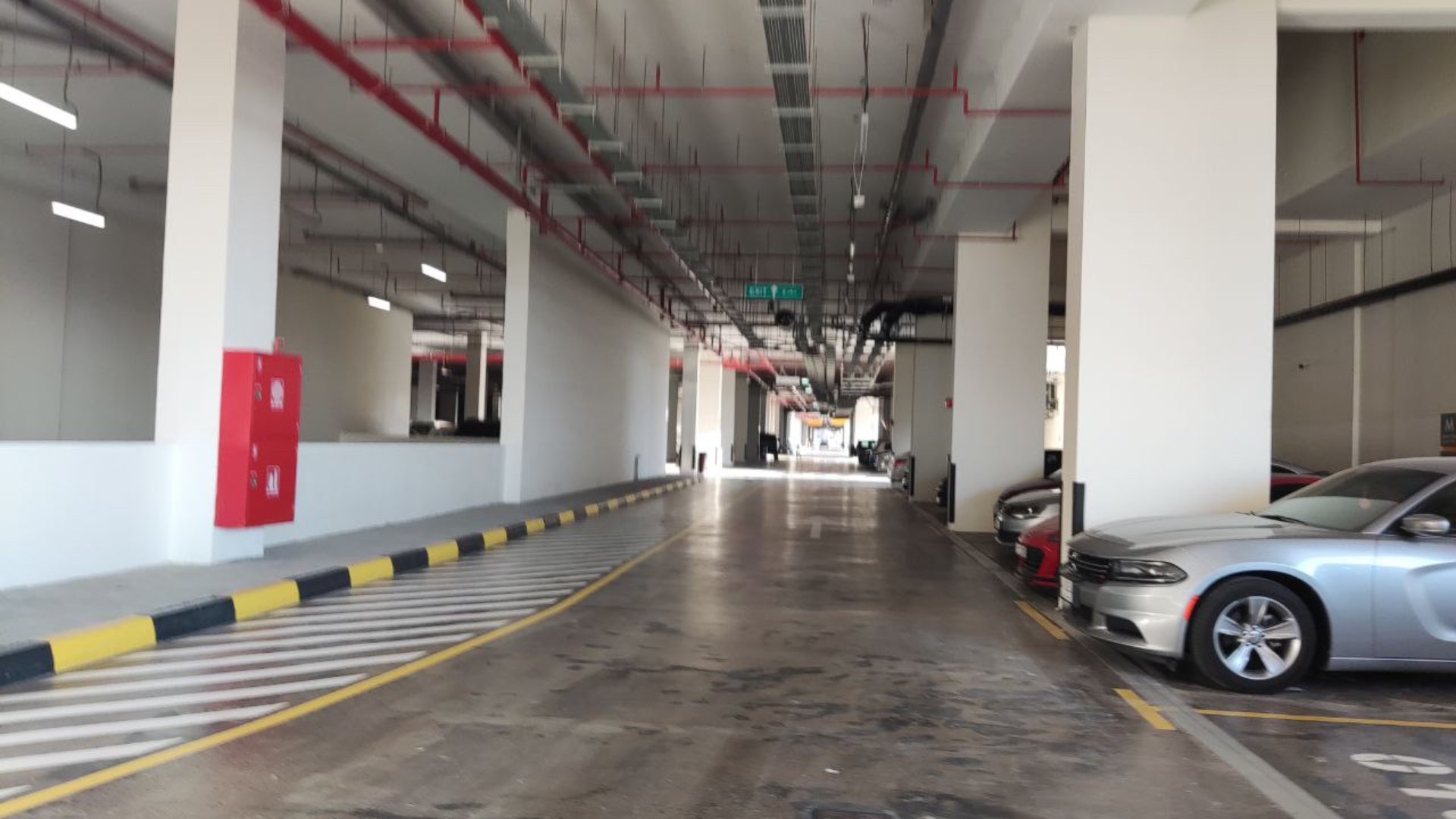 "Exterior view of modern apartment building for sale in Al Jaddaf, featuring spacious balconies.",Underground parking area of spacious 3-bedroom apartment for sale in Al Jaddaf