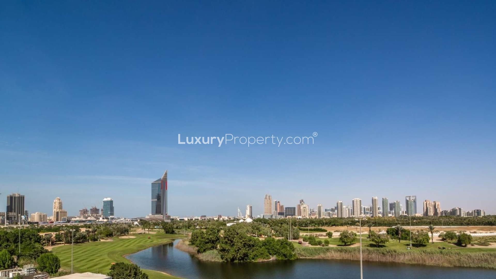 Spacious living room with large windows, offering stunning views of Emirates Golf Course