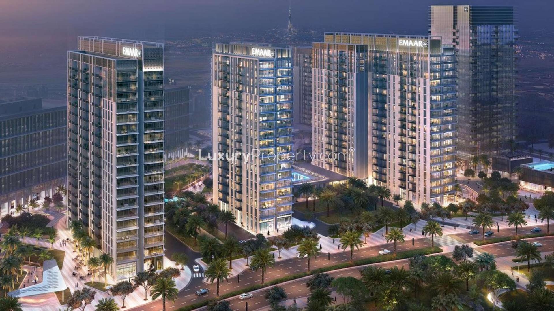 "Luxurious Dubai Hills Estate apartment balcony with pool view at sunset, Park Heights.",Aerial view of Park Heights apartments in Dubai Hills Estate at night, featuring modern architecture