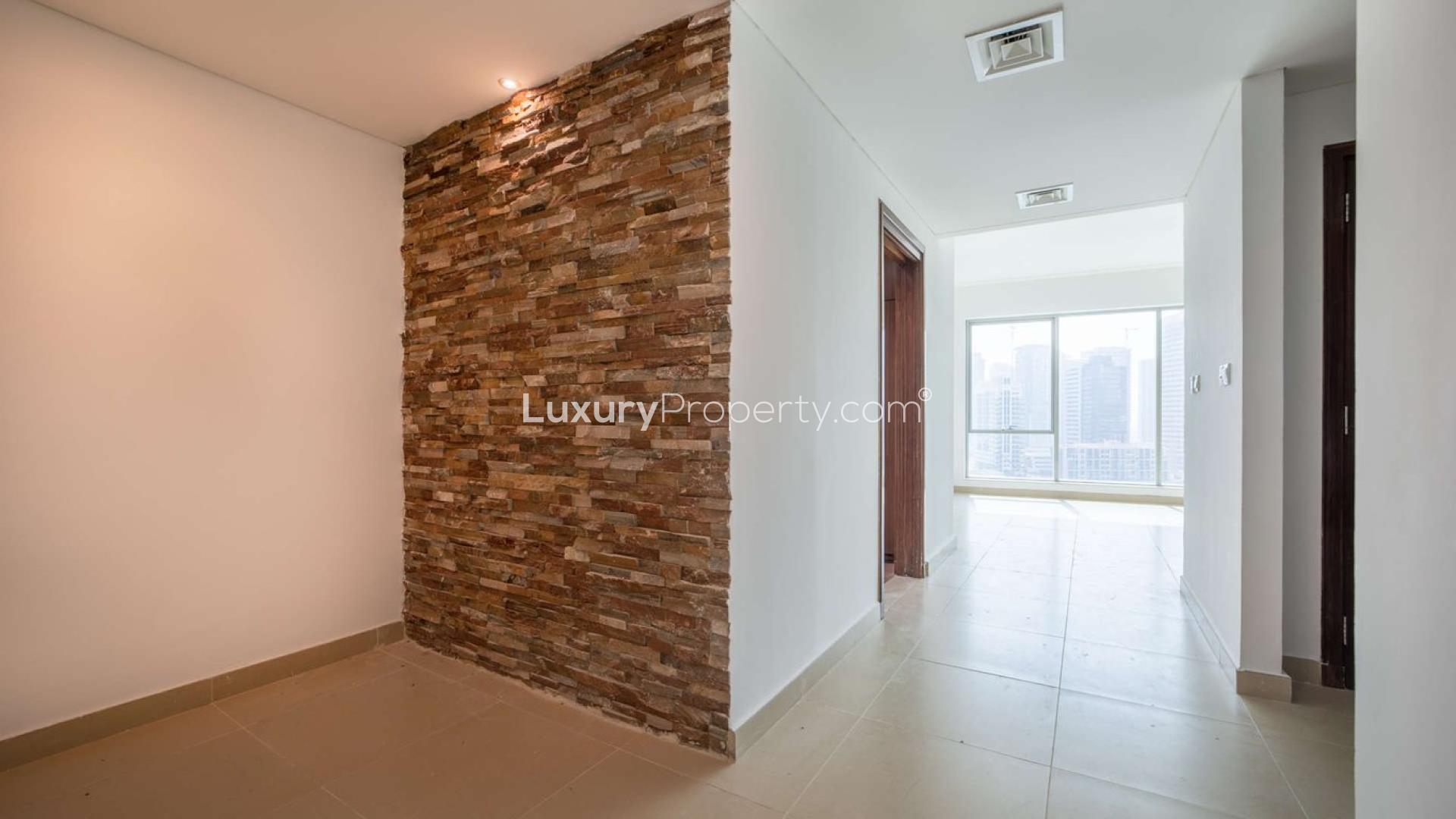 "Bright apartment with stunning marina views in Paloma Tower, Dubai Marina, for sale.",Modern hallway with stone accent wall in Paloma Tower apartment, Dubai Marina