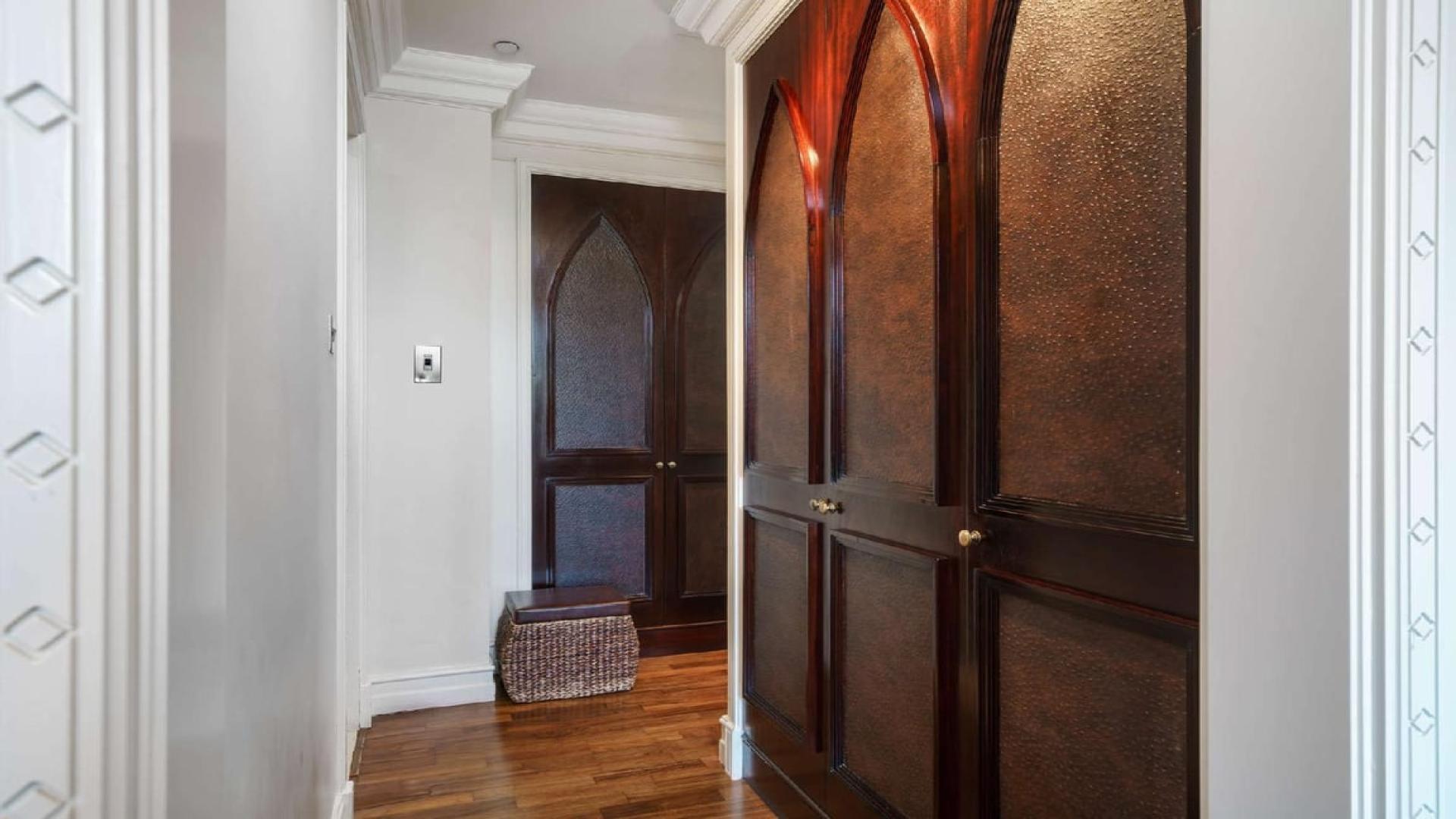 "Spacious balcony view from three-bedroom apartment in Old Town Island near Burj Khalifa.",Elegant hallway with wooden doors in Old Town Island apartment, Dubai