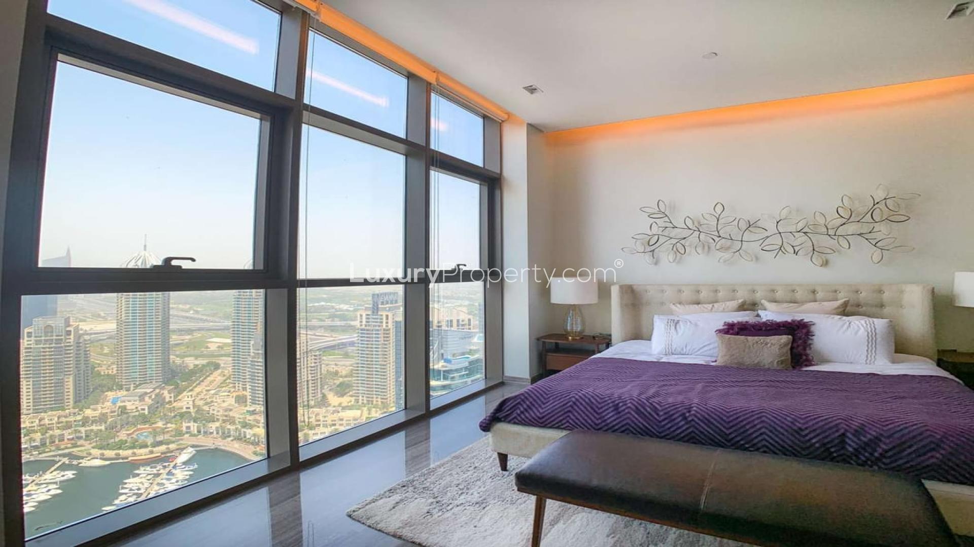 Luxurious bedroom with stunning Dubai Marina views, featuring large windows and modern decor