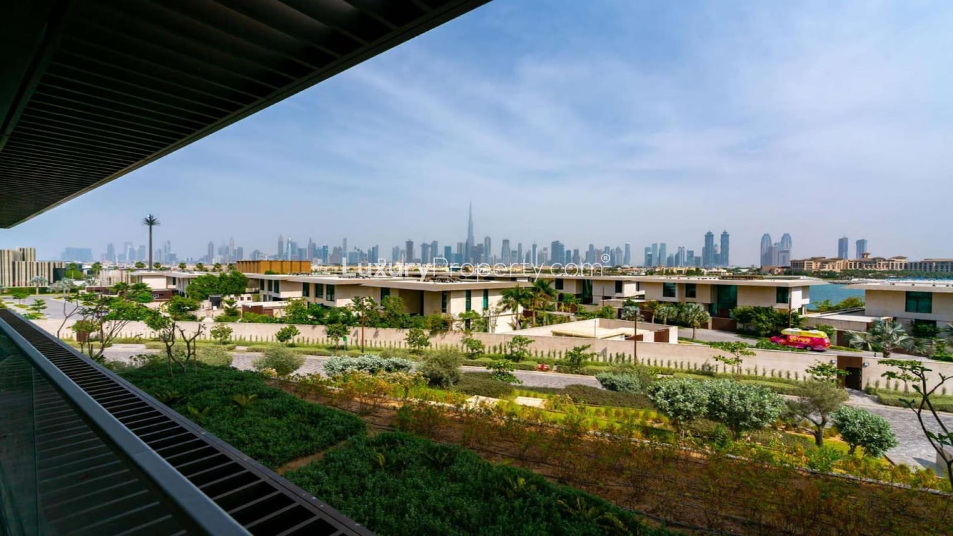 Luxurious Jumeirah Bay apartment view, lush gardens, Dubai skyline in the background