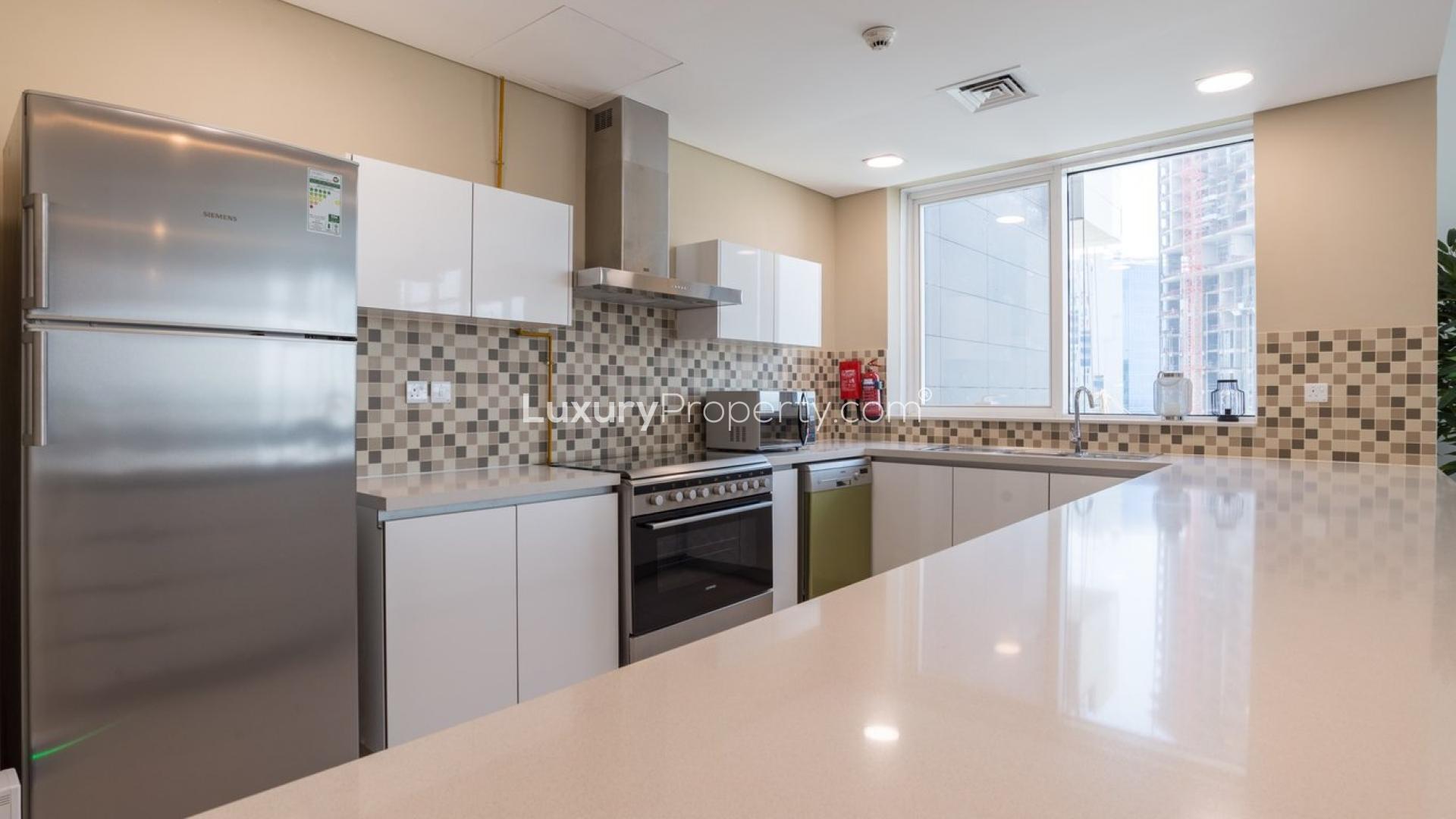 Modern kitchen in Vezul Residence apartment, Business Bay, featuring sleek appliances and spacious countertops