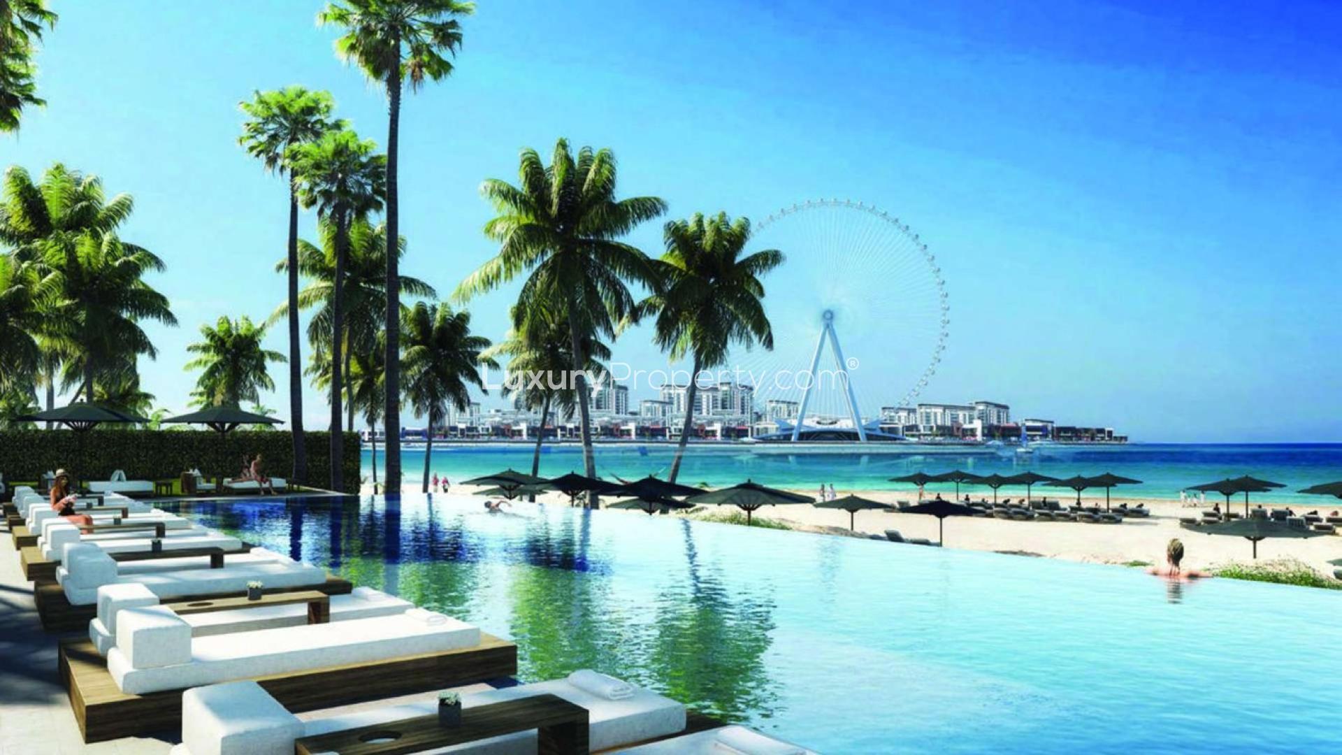 La Vie Jumeirah Beach Residence pool area with luxury lounge chairs and lush greenery