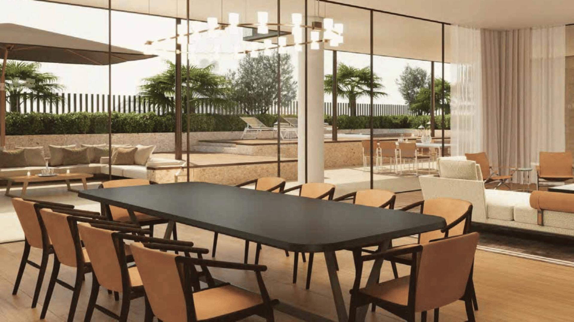 Luxurious apartment exterior on Jumeirah Bay Island, surrounded by palm trees and people