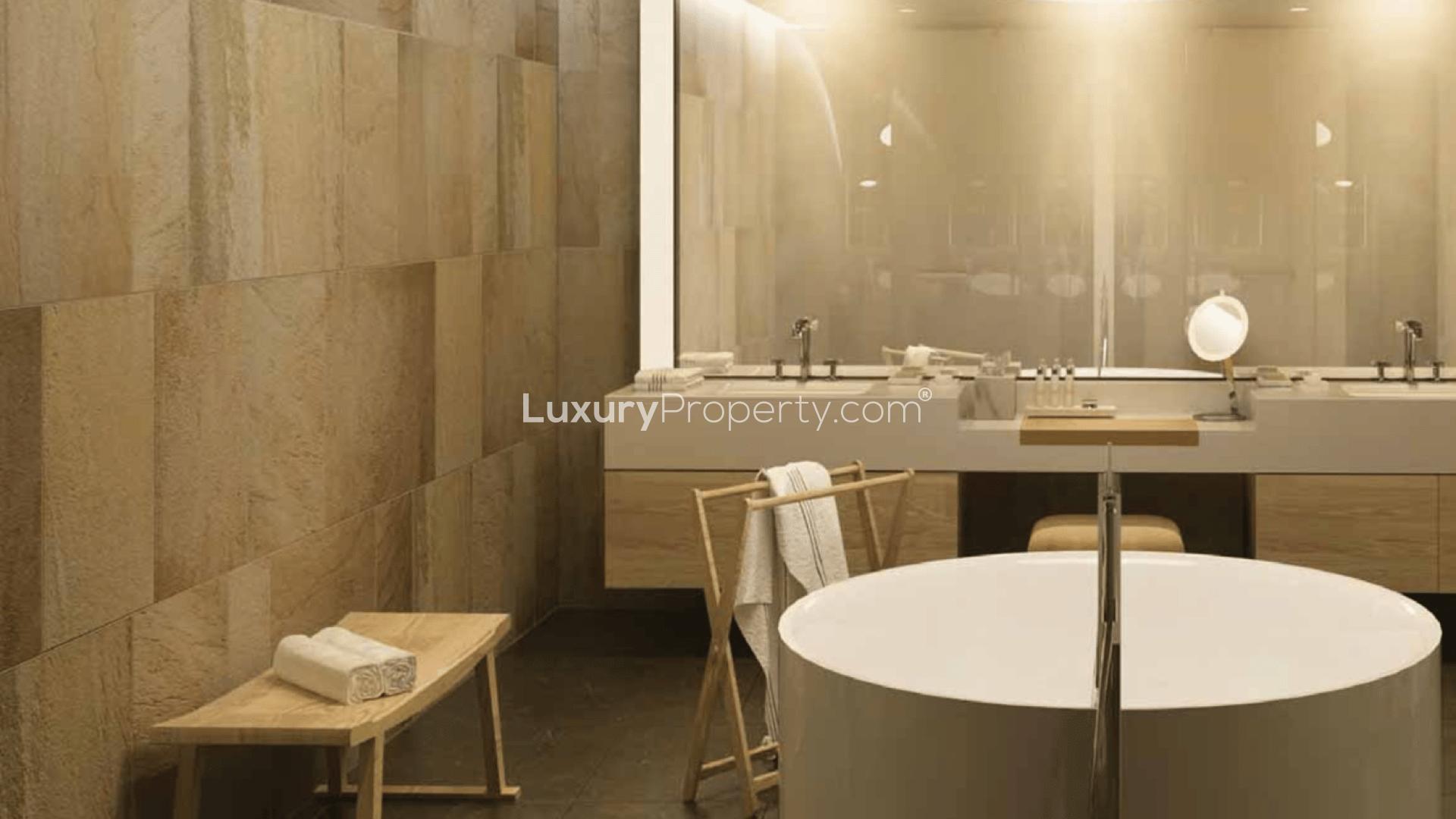 Luxurious waterfront apartment building on Jumeirah Bay Island with yachts and palm-lined walkway