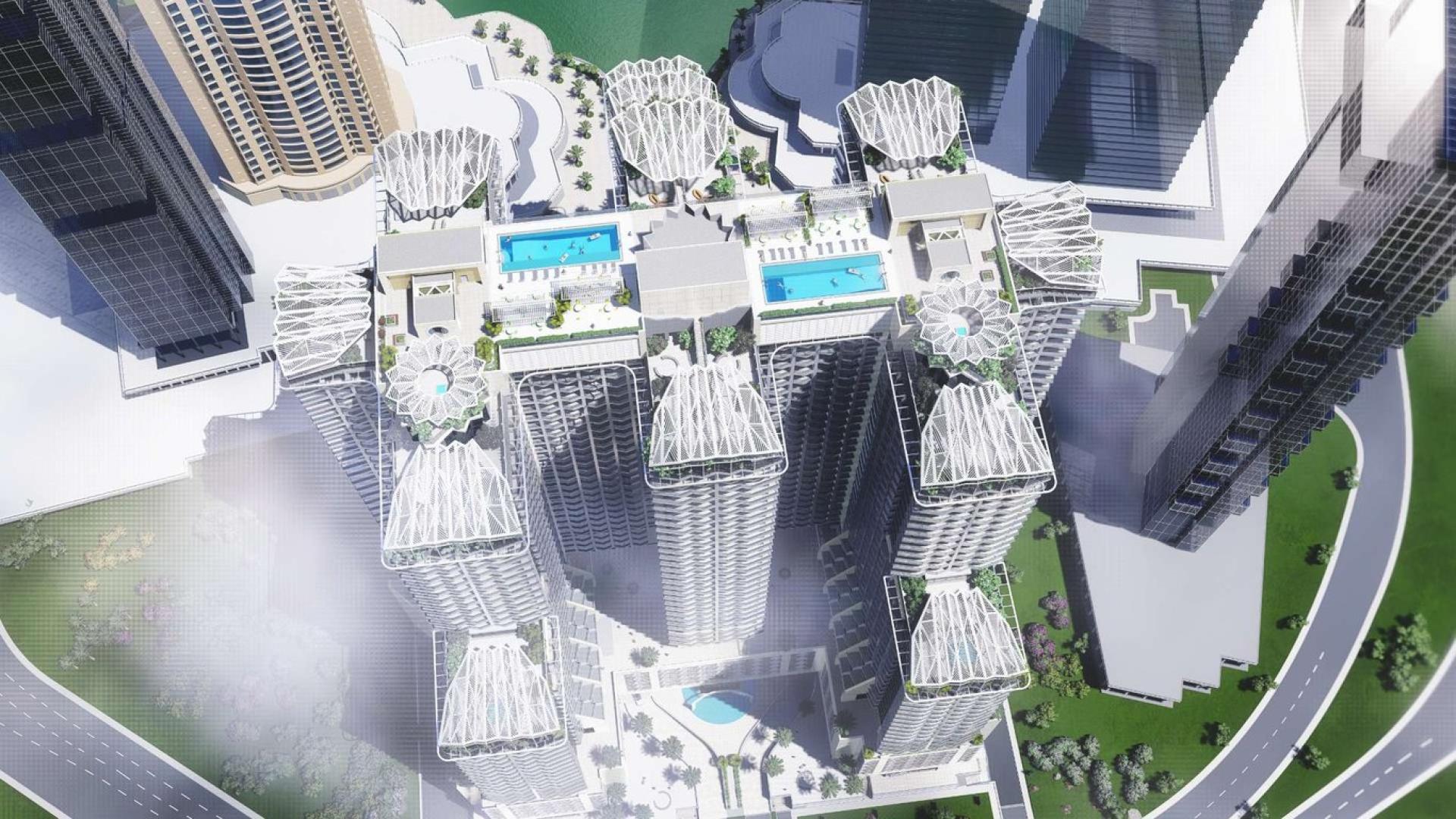 Aerial view of Se7en City JLT apartment complex with pools and green surroundings