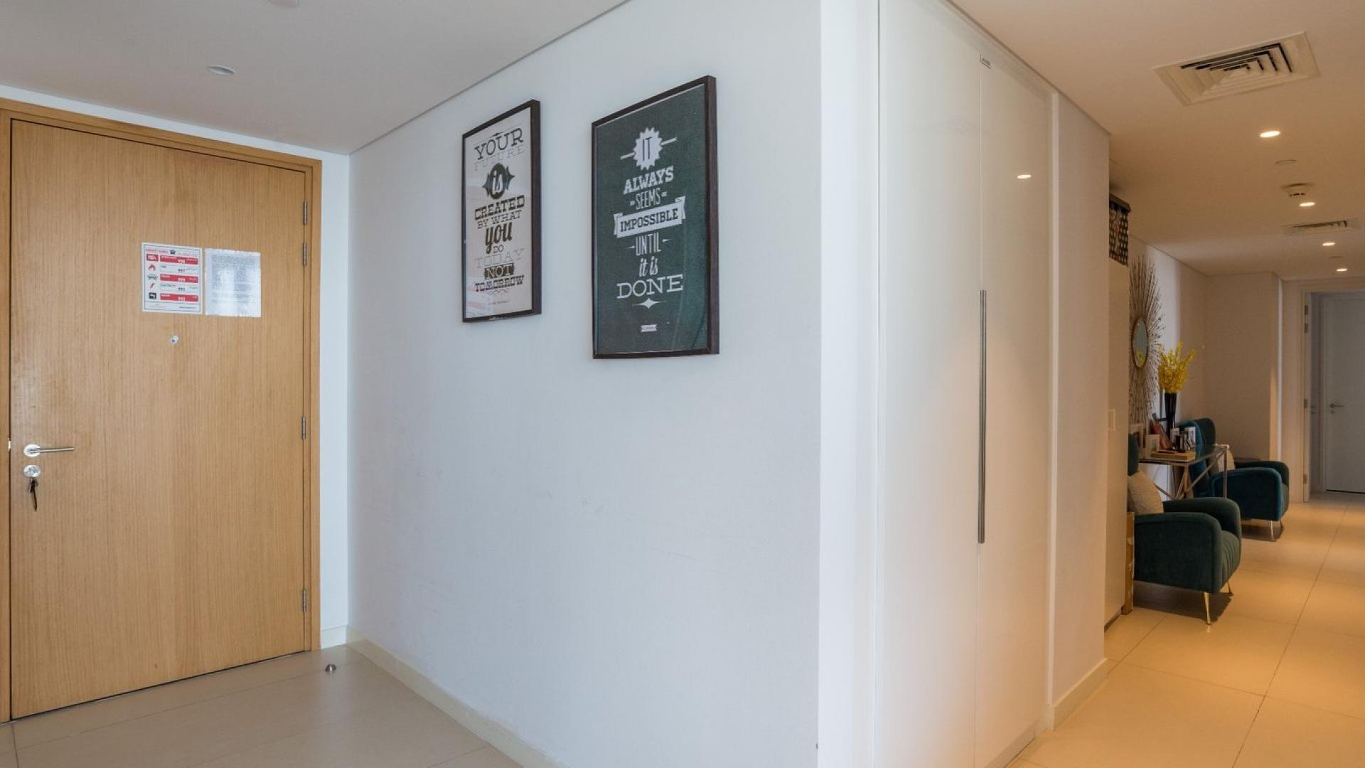 Entryway of renovated 3-bedroom apartment on Bluewaters Island, featuring modern decor and seating