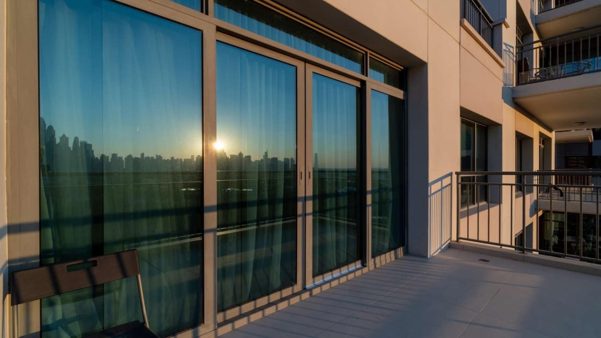 "Stunning sunset view from 3-bedroom triplex apartment balcony in Panorama, The Views.","Sunlit balcony view from triplex apartment in Panorama, The Views, Dubai skyline visible.",Sunny balcony view of 3-bedroom triplex apartment in Panorama, The Views