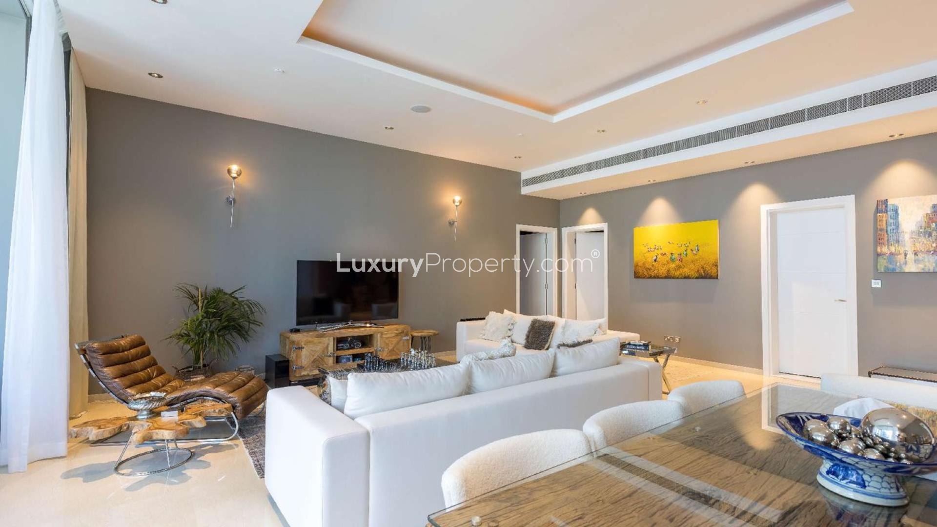 Luxurious living room in upgraded Palm Jumeirah apartment, featuring modern decor and cozy seating