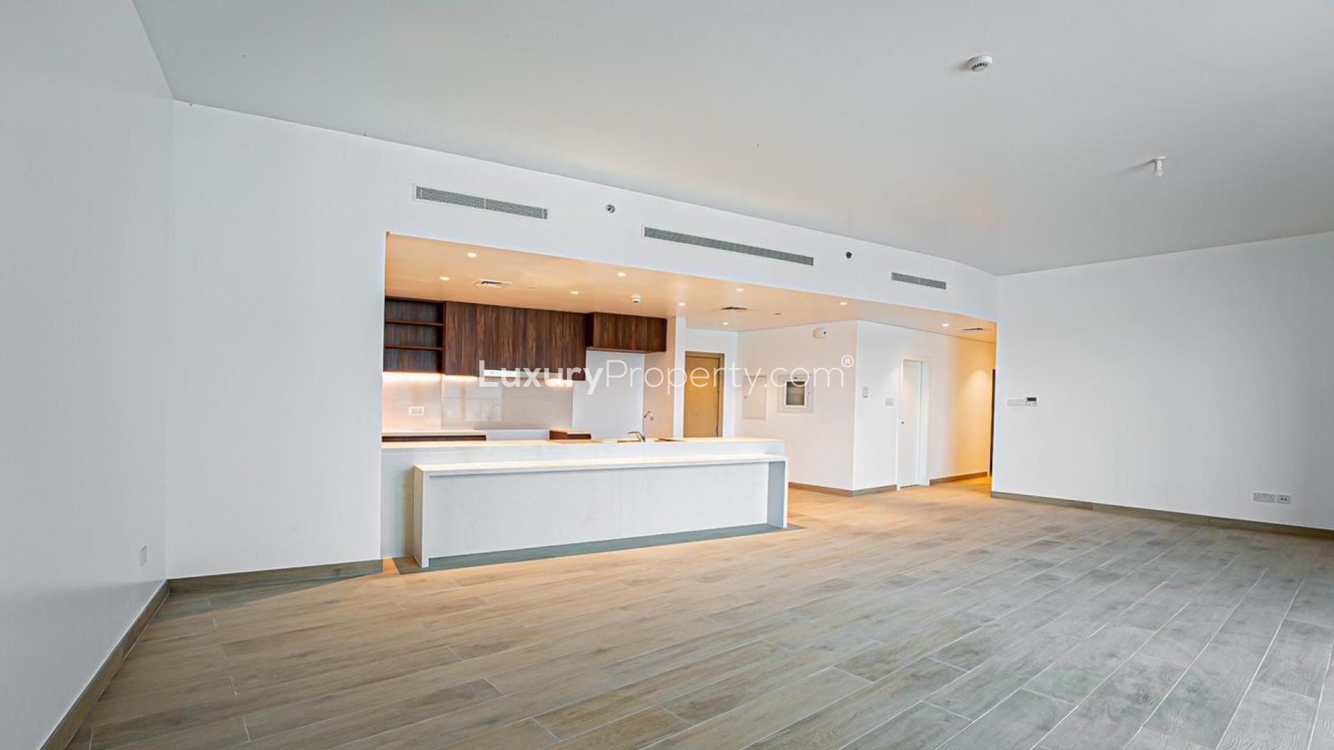Modern open-plan kitchen and living area in Jumeirah La Mer waterfront apartment for sale