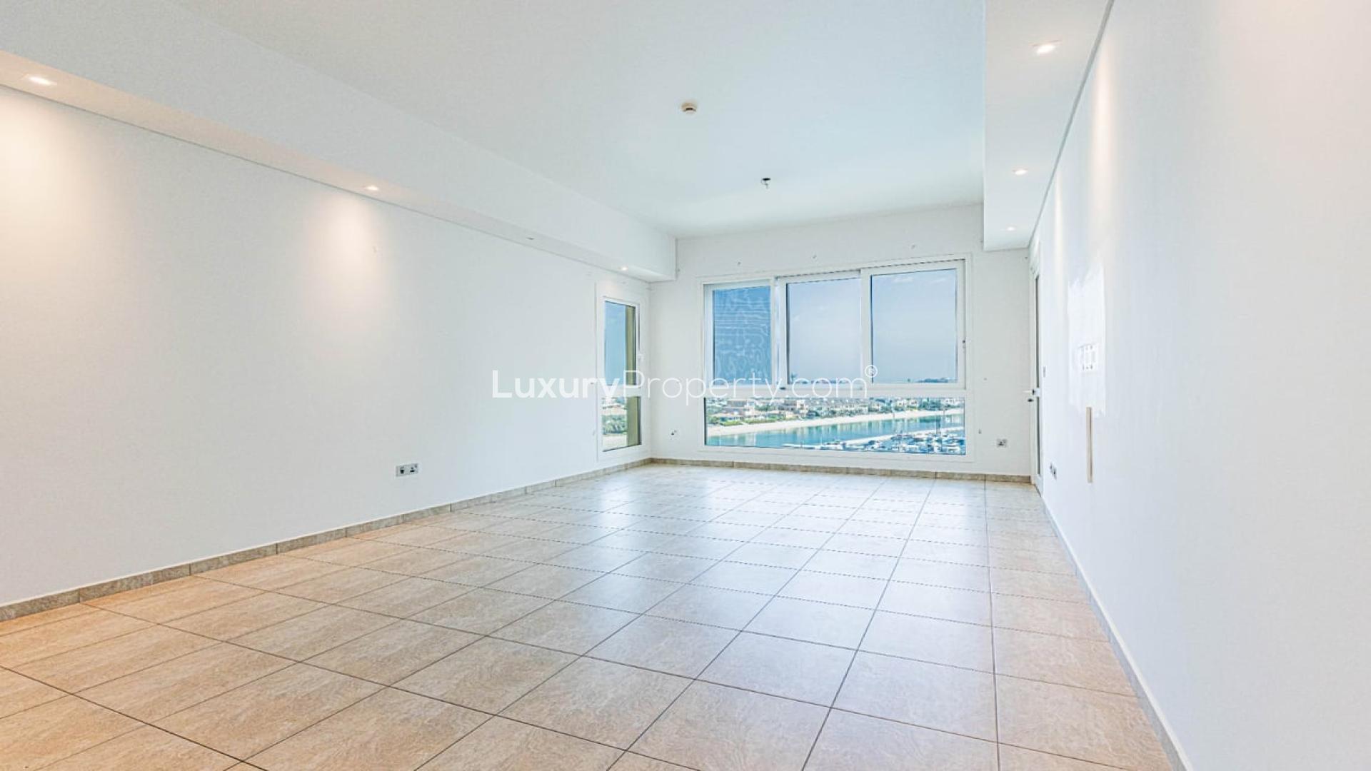 "Stunning sea view from Palm Jumeirah apartment, overlooking marina and luxury yachts.",Empty apartment living room with sea view windows in Palm Jumeirah, Marina Residences