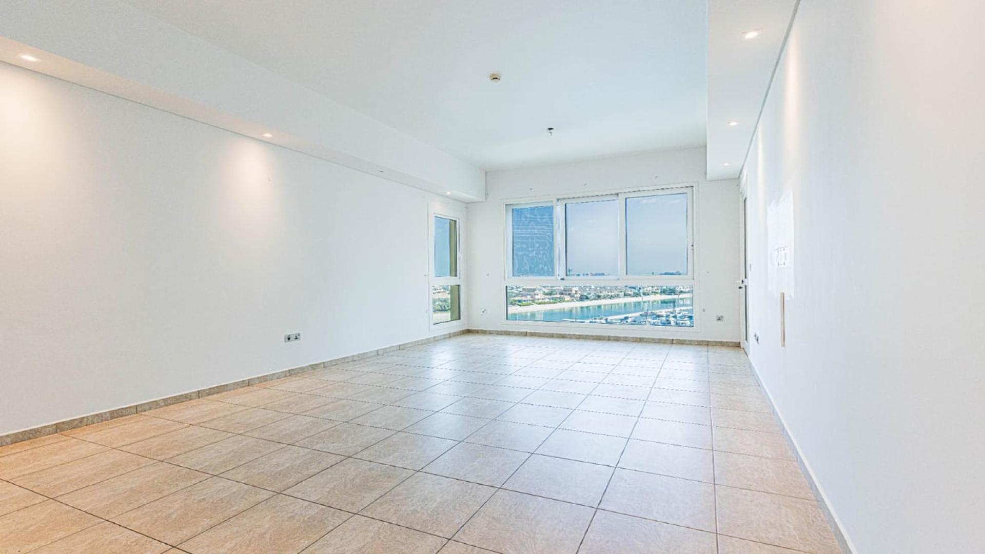 "Stunning sea view from Palm Jumeirah apartment, overlooking marina and luxury yachts.",Empty apartment living room with sea view windows in Palm Jumeirah, Marina Residences