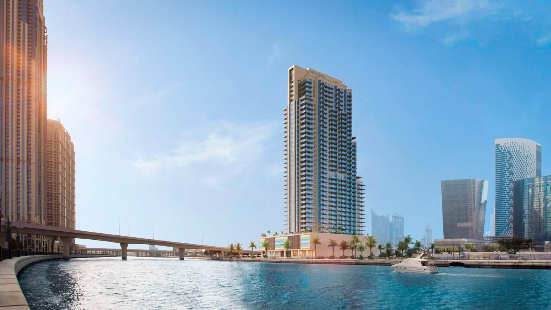 Luxury penthouse balcony with stunning Dubai Canal view, modern seating area, glass railing