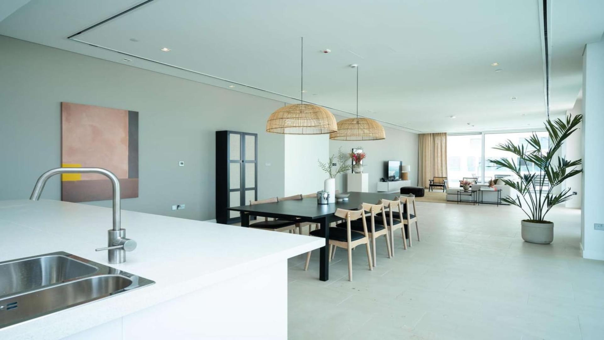 Modern open-plan living area in Al Barari duplex penthouse, featuring elegant dining space
