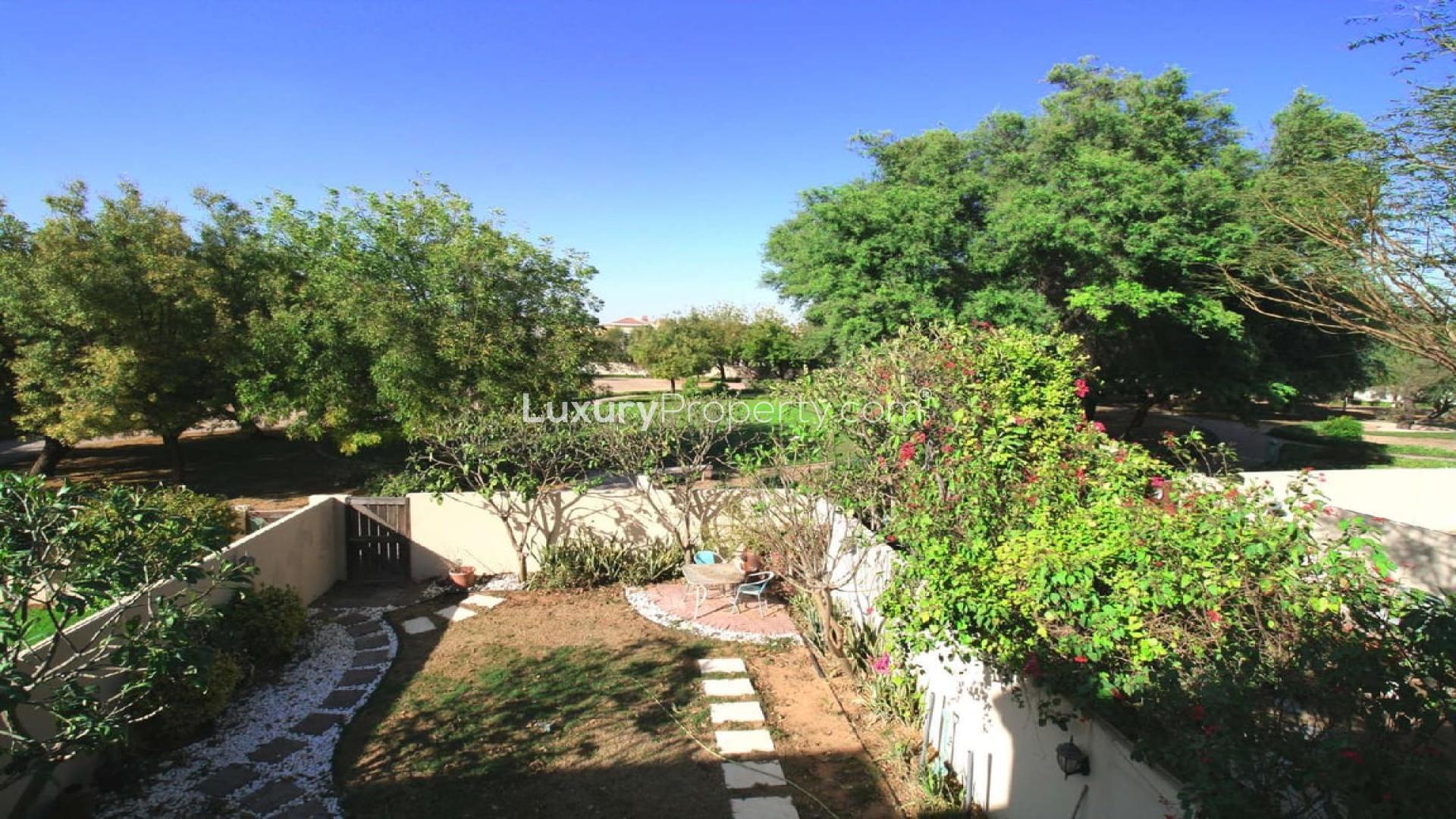 Modern living room in Al Reem townhouse, Arabian Ranches, with garden view through glass doors