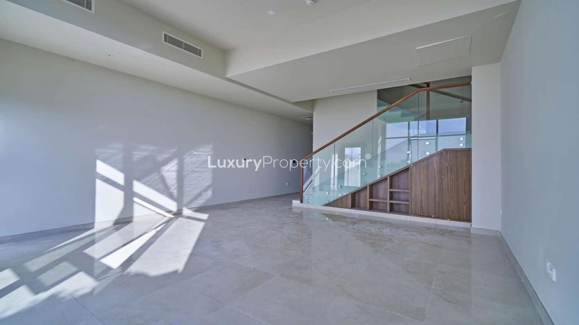 "Modern 3-bedroom townhouse exterior with parking in Al Furjan's Murano Residences for rent.",Modern living room in Al Furjan townhouse with sleek staircase and natural light
