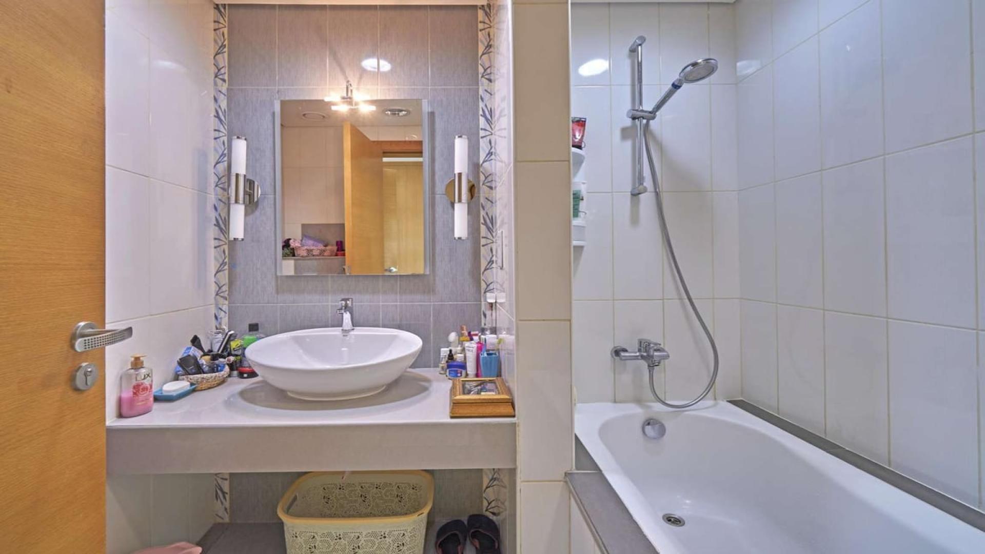 Modern kitchen in Quortaj-style townhouse, Al Furjan North Village, with island and bar stools