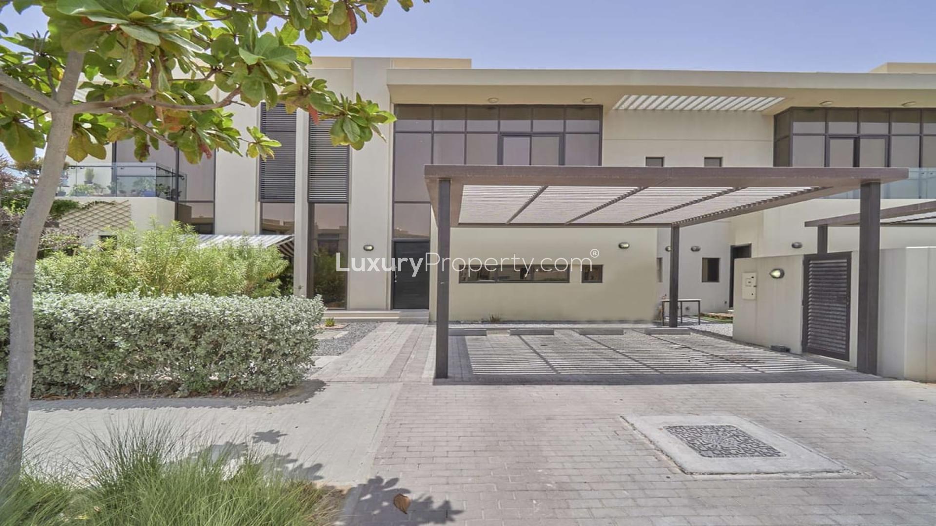 Spacious three-bedroom townhouse exterior with carport in Topanga, Damac Hills for rent