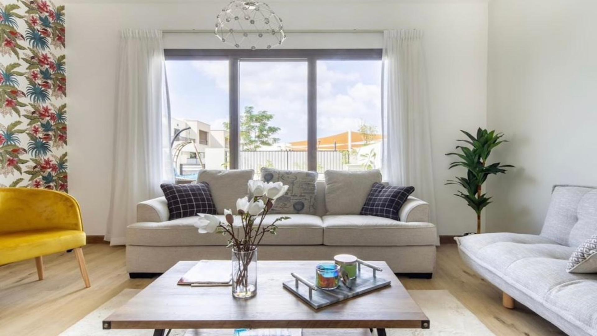 Fully furnished living room in Hayat townhouse, Town Square, with modern decor and natural light