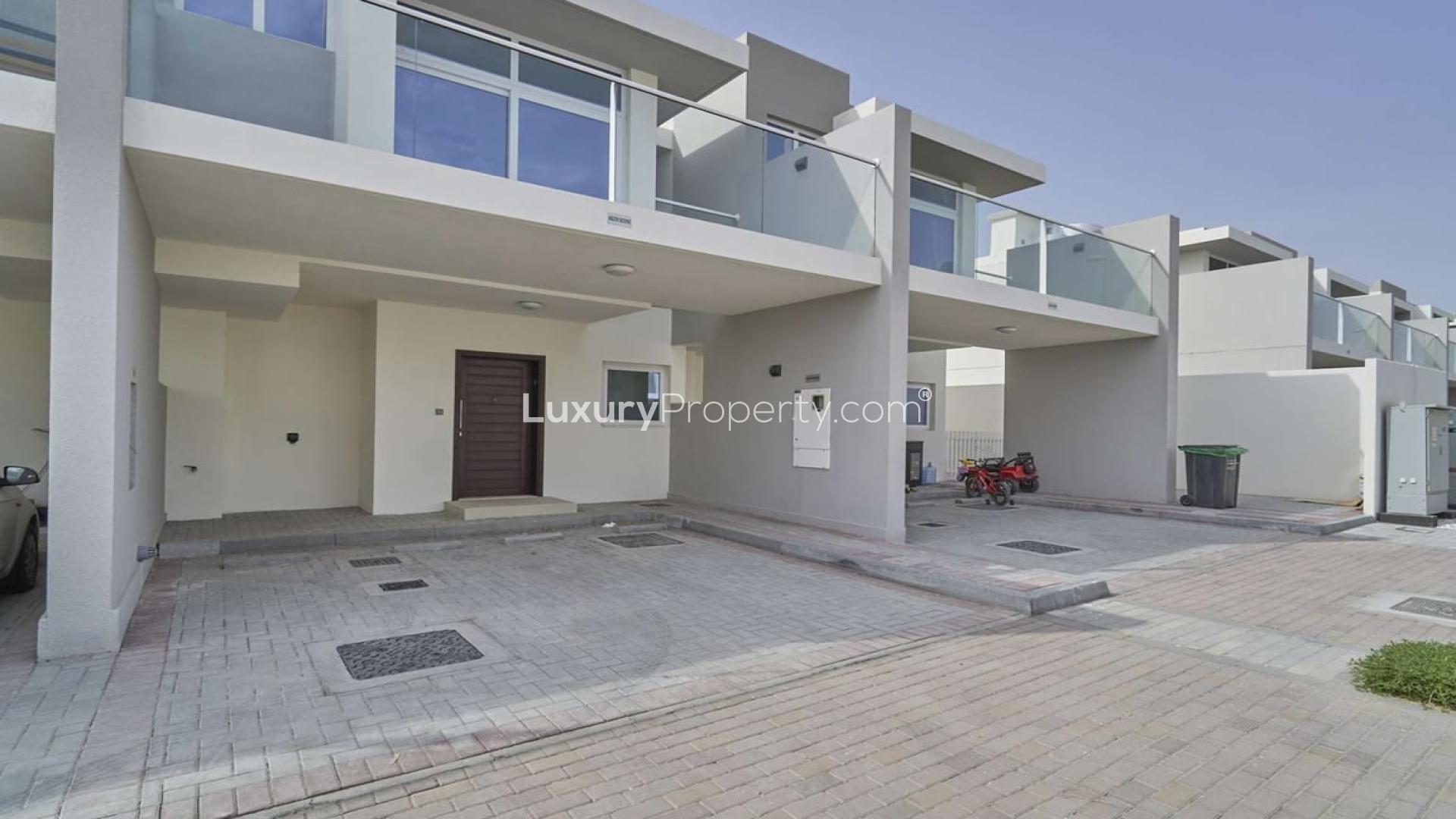 Row of modern townhouses in Albizia, Damac Hills 2, available for rent with private gardens