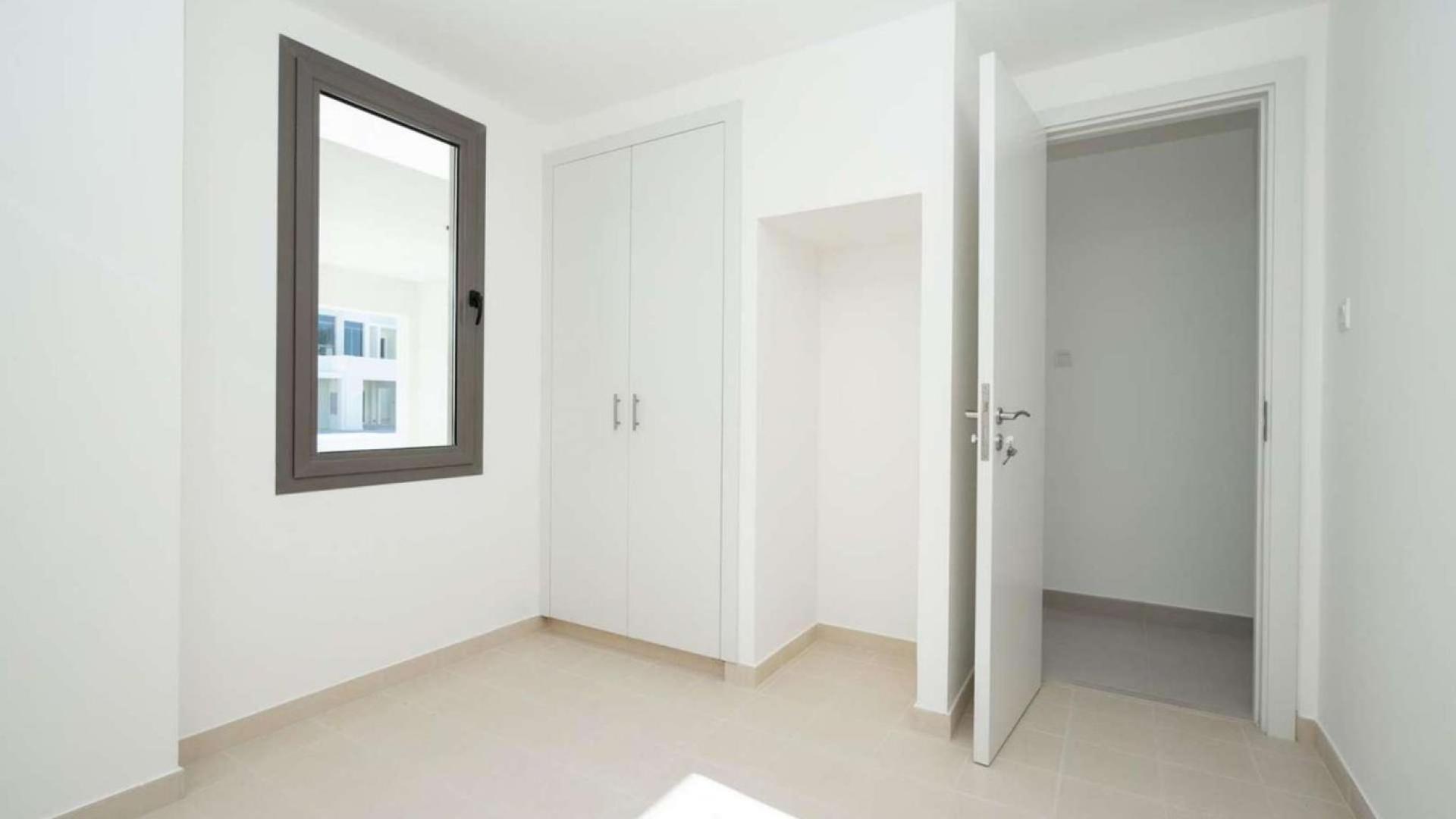 Modern open-plan living area in Hayat Townhouse, Town Square, with large windows and kitchen