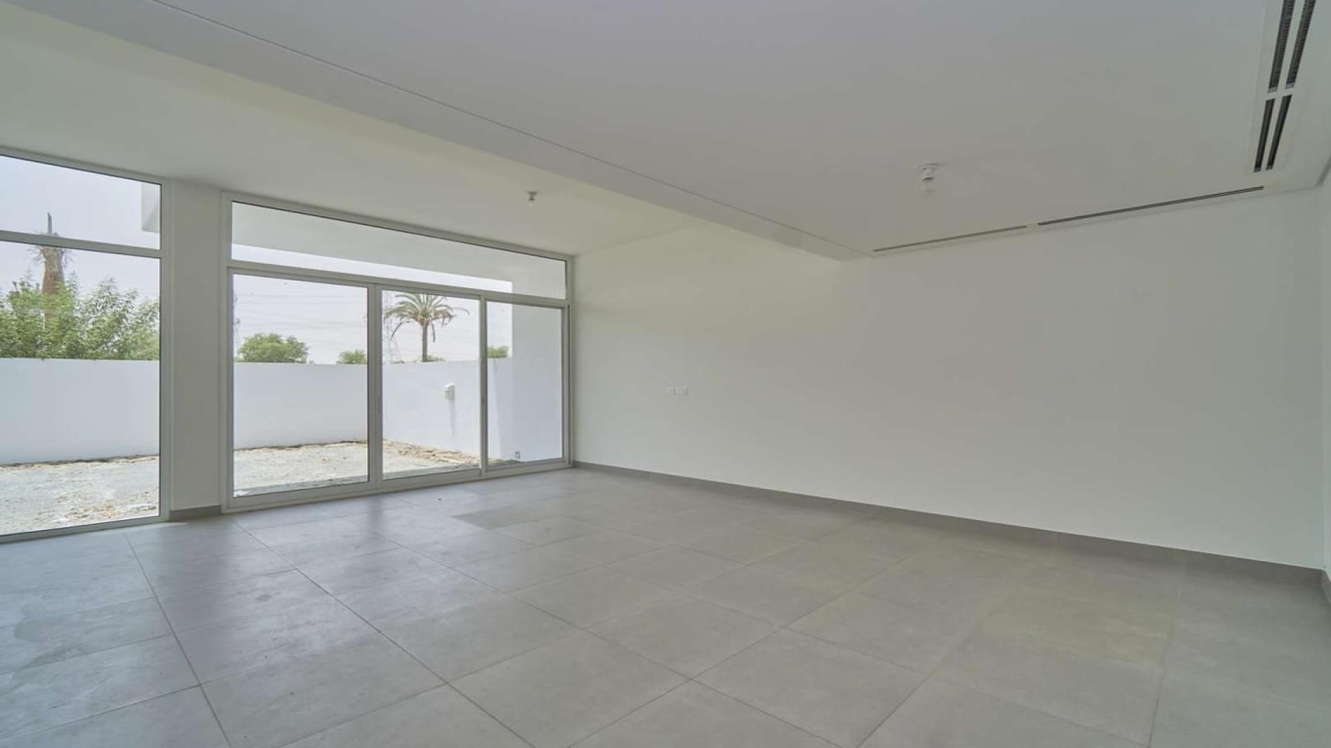 Spacious living room in Arabella 3 Mudon townhouse with large windows and garden view