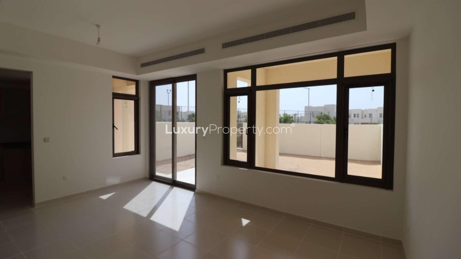Bright living room in Mira Oasis 3 townhouse with large windows and outdoor access