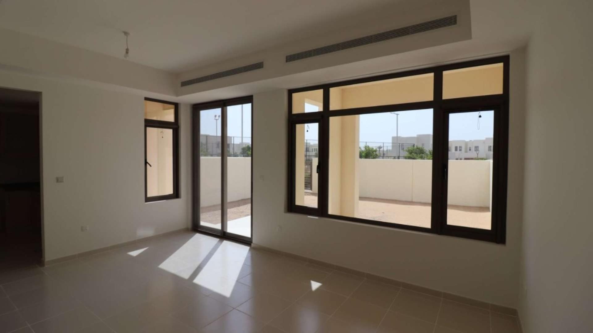 Bright living room in Mira Oasis 3 townhouse with large windows and outdoor access