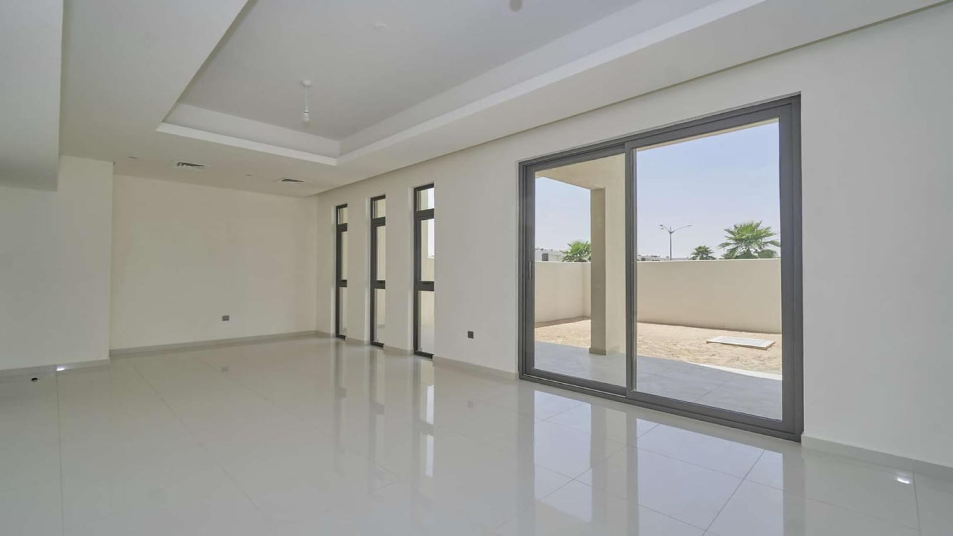 Modern kitchen in Damac Hills 2 townhouse, featuring sleek cabinetry and large window