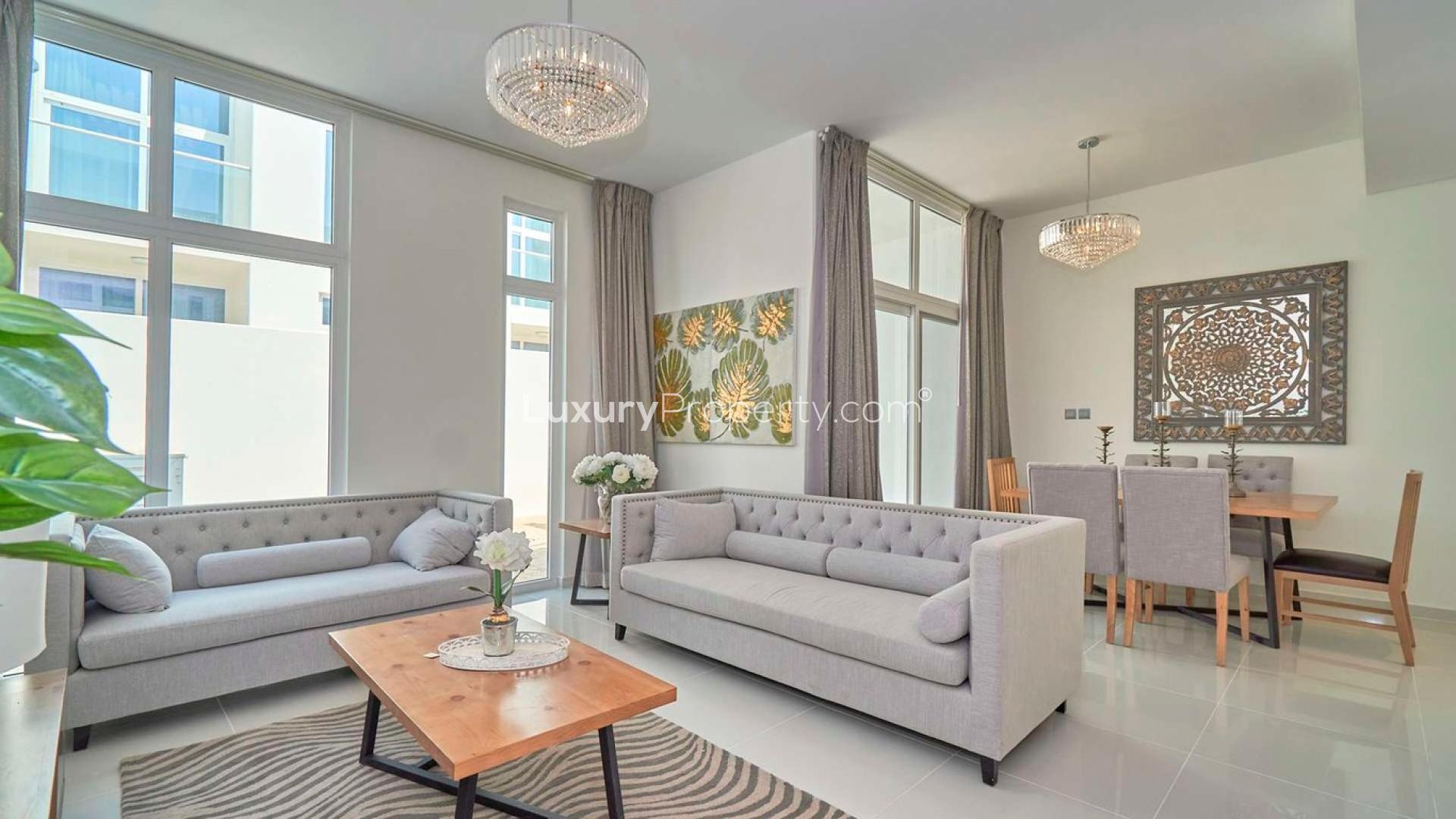 Fully furnished living room in Damac Hills 2 townhouse with modern decor and staircase