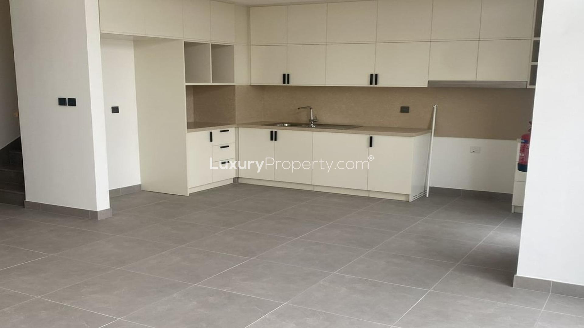 Modern kitchen in Arabian Ranches 3 townhouse for rent, featuring sleek cabinetry and large windows