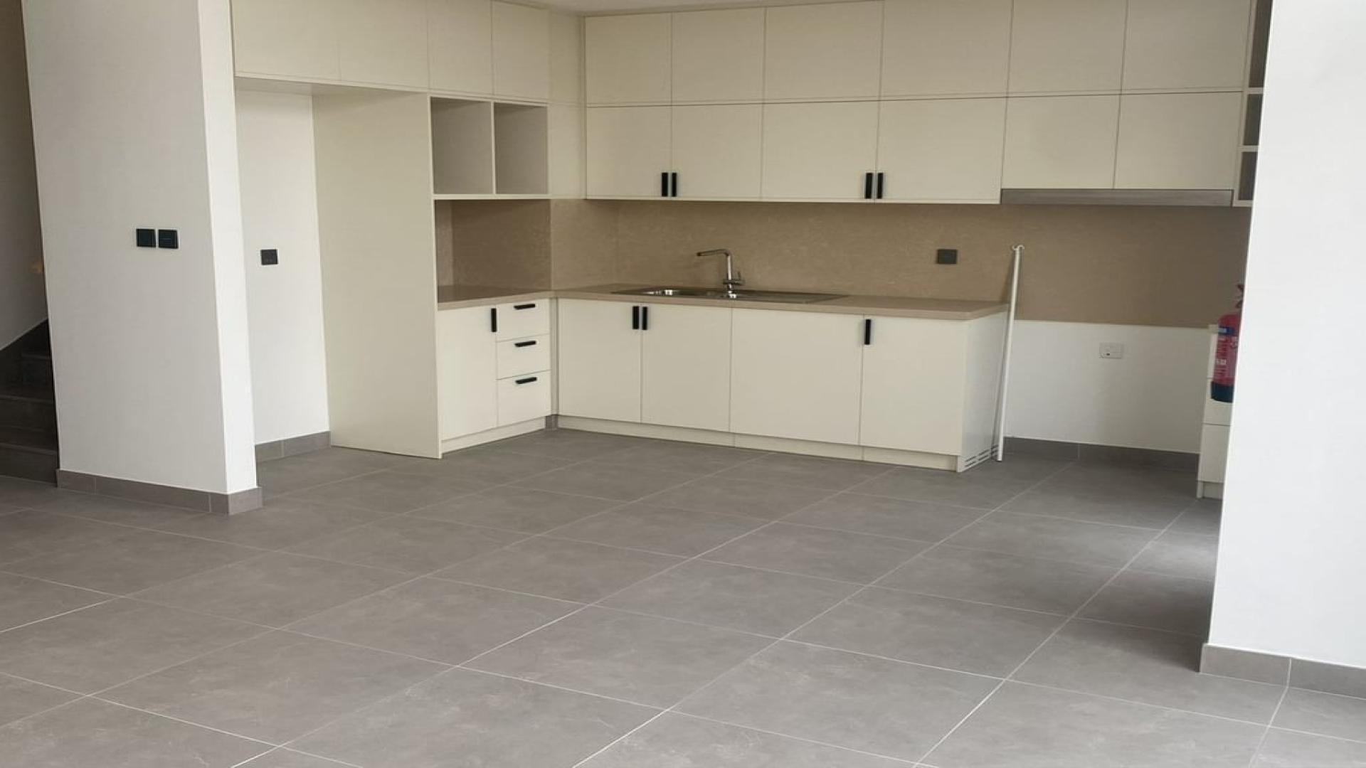 Modern kitchen in Arabian Ranches 3 townhouse for rent, featuring sleek cabinetry and large windows