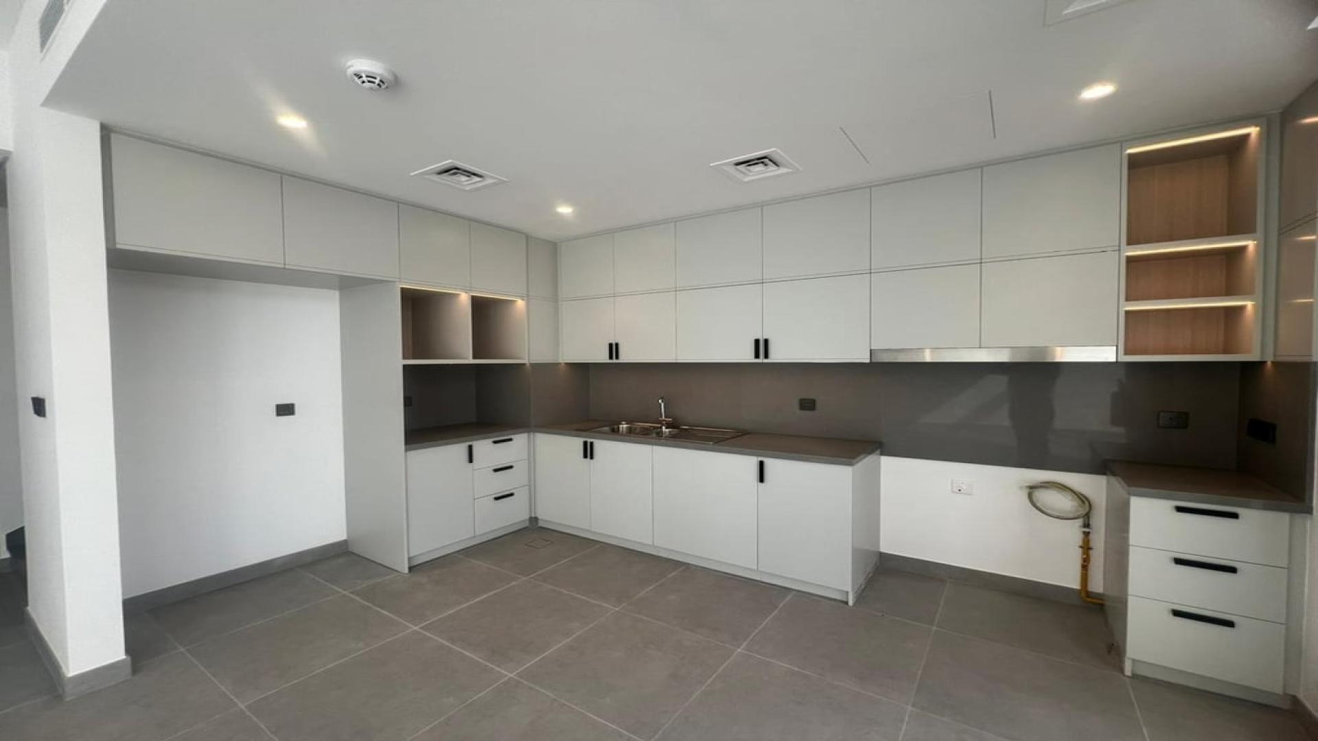 Modern kitchen and living area in Ruba townhouse, Arabian Ranches III, for rent