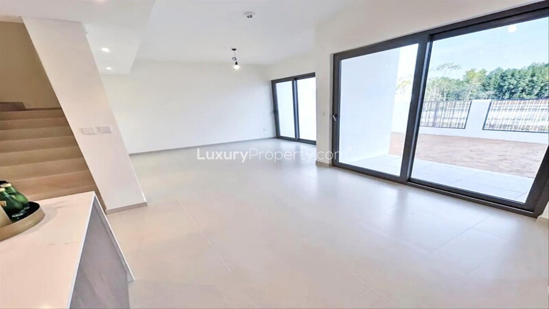 Bright living room in Elan townhouse, Tilal Al Ghaf, with large windows and patio view