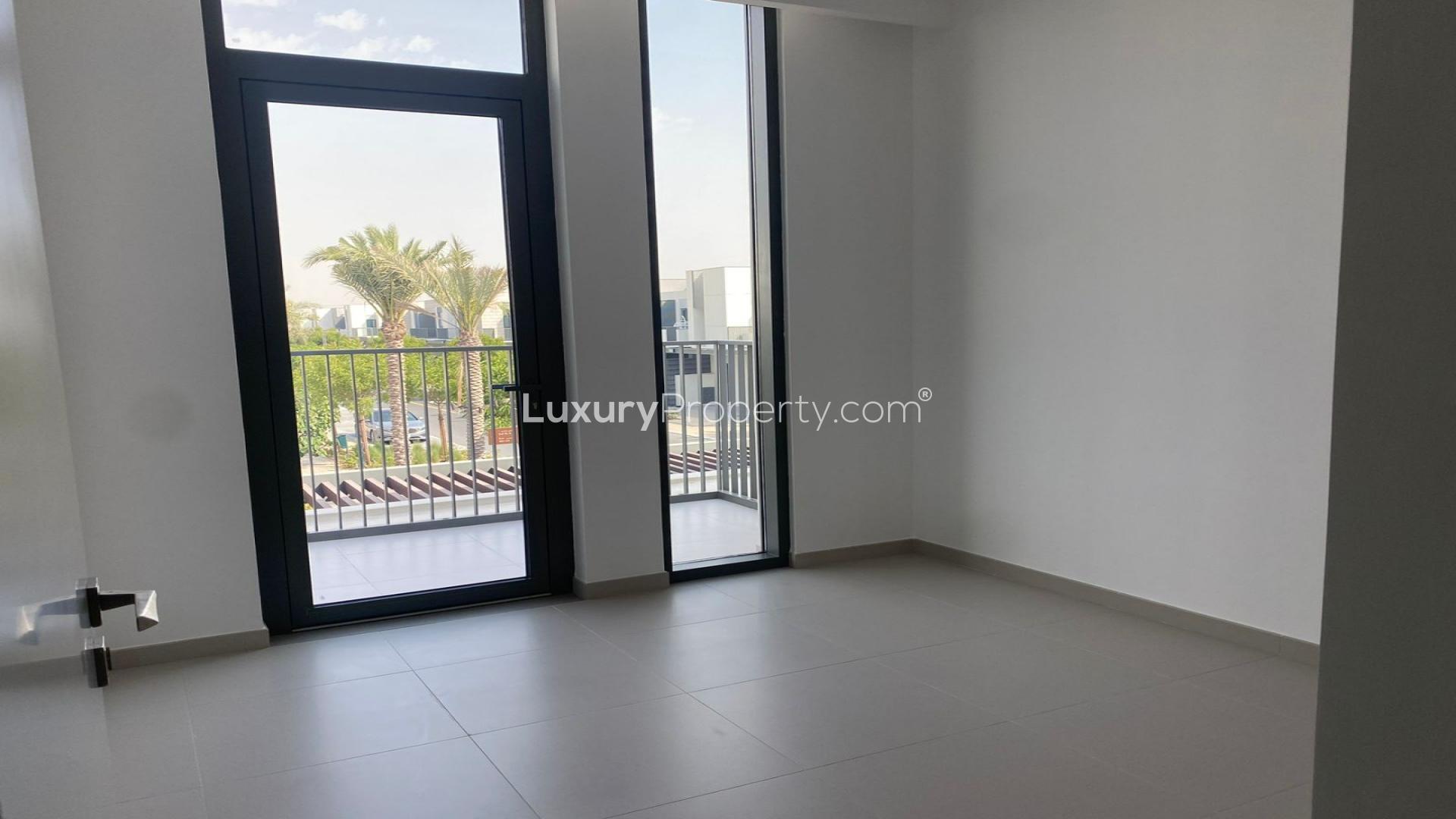 Empty room with large windows overlooking a private garden in Arabian Ranches 3 townhouse