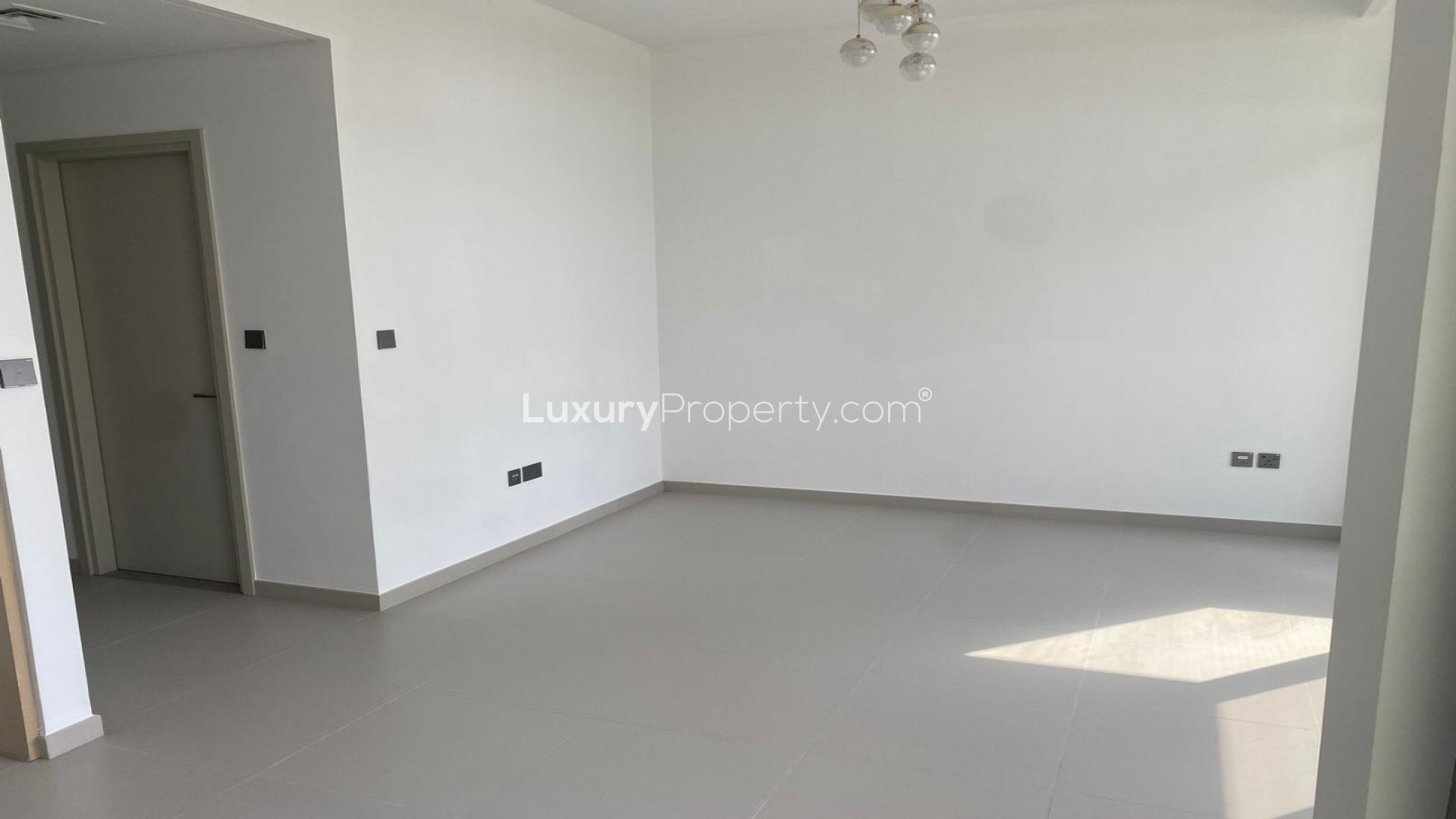 "Bright living room with large windows overlooking private garden in Arabian Ranches 3 townhouse.",Empty living room in 3-bedroom townhouse, Sun community, Arabian Ranches 3, available for rent