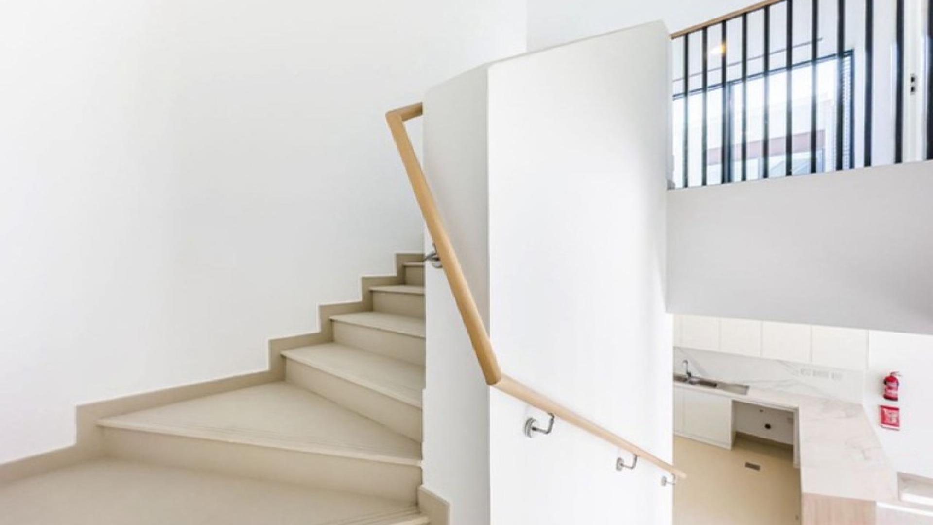 Brand new modern villa interior with open kitchen and staircase in Cherrywoods, Dubai Land