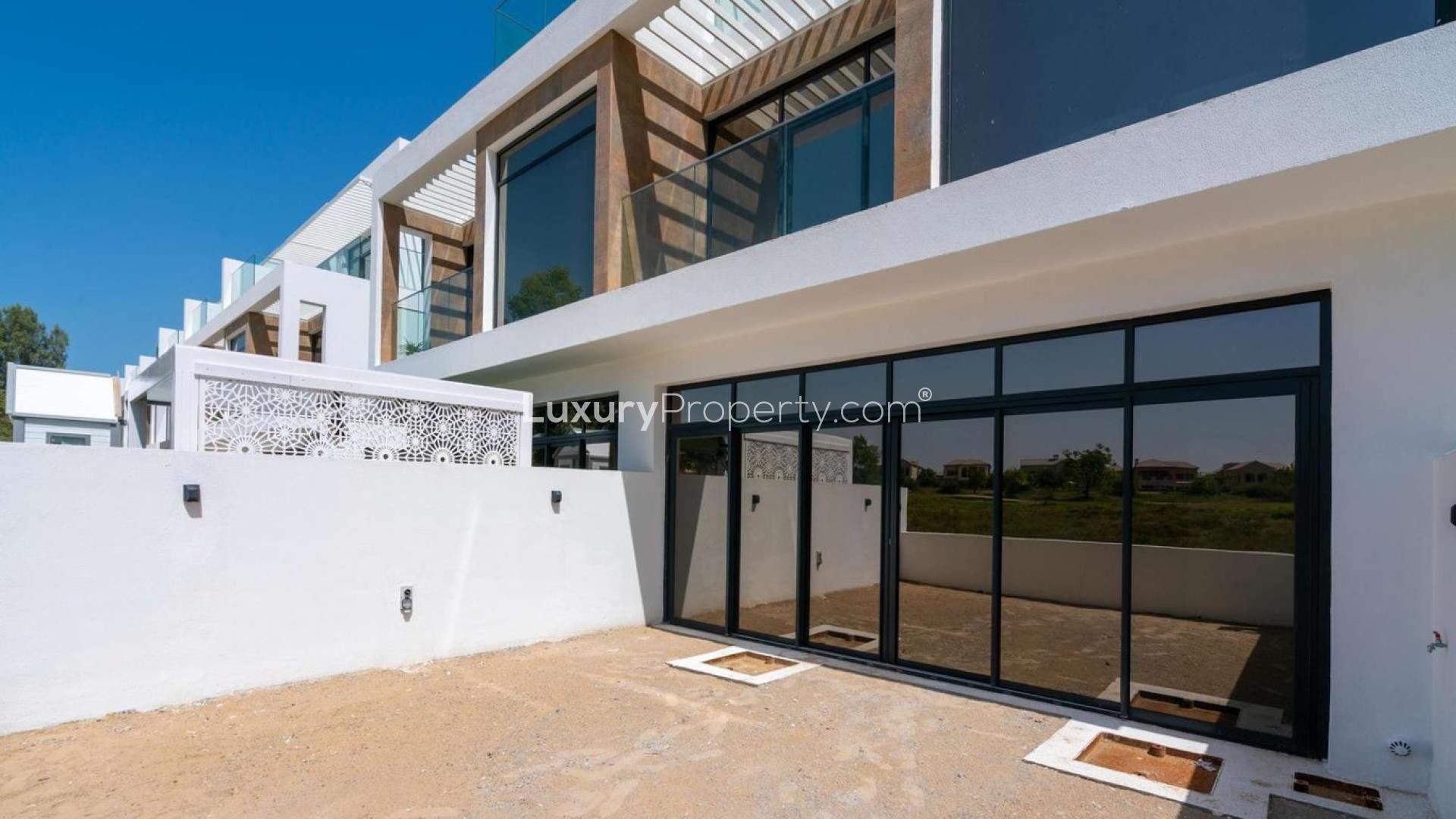 Alt text: "Modern 4-bedroom villa exterior in Jumeirah Luxury Living, Jumeirah Golf Estates, for sale.",Exterior view of luxury villa in Jumeirah Golf Estates, featuring modern architecture
