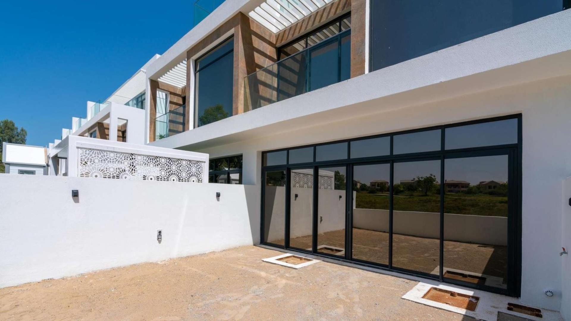 Alt text: "Modern 4-bedroom villa exterior in Jumeirah Luxury Living, Jumeirah Golf Estates, for sale.",Exterior view of luxury villa in Jumeirah Golf Estates, featuring modern architecture