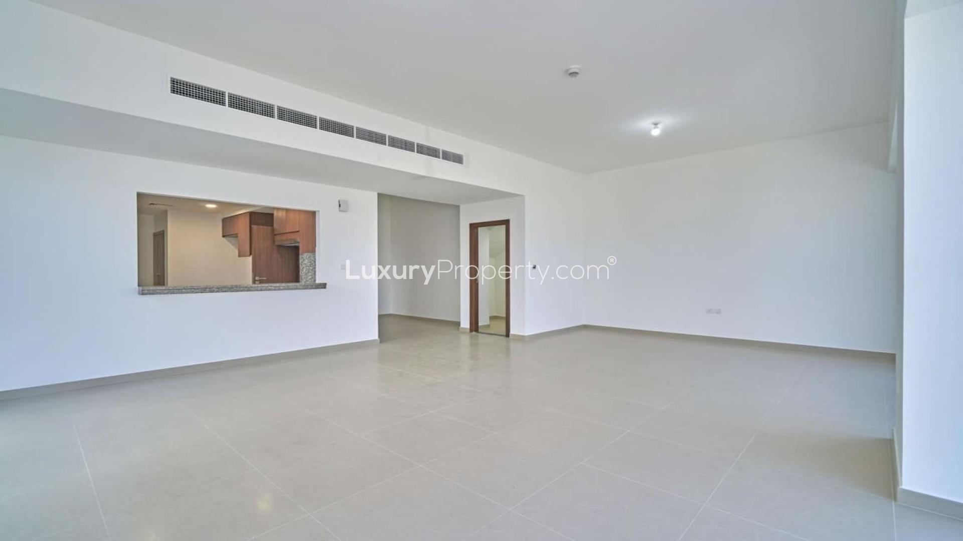 Empty living room with large windows in Arabella Townhouses, Mudon