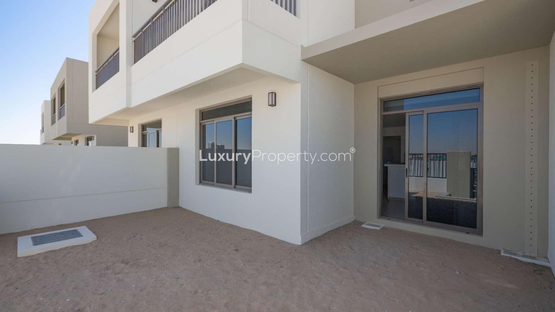 "Spacious backyard of 3-bedroom townhouse for sale in Noor, Town Square community.",Immaculate townhouse exterior in Noor, Town Square with patio and sliding glass doors