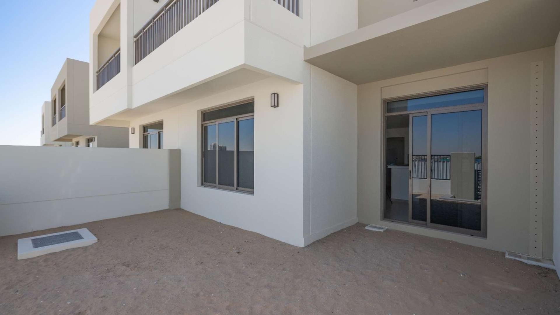 "Spacious backyard of 3-bedroom townhouse for sale in Noor, Town Square community.",Immaculate townhouse exterior in Noor, Town Square with patio and sliding glass doors